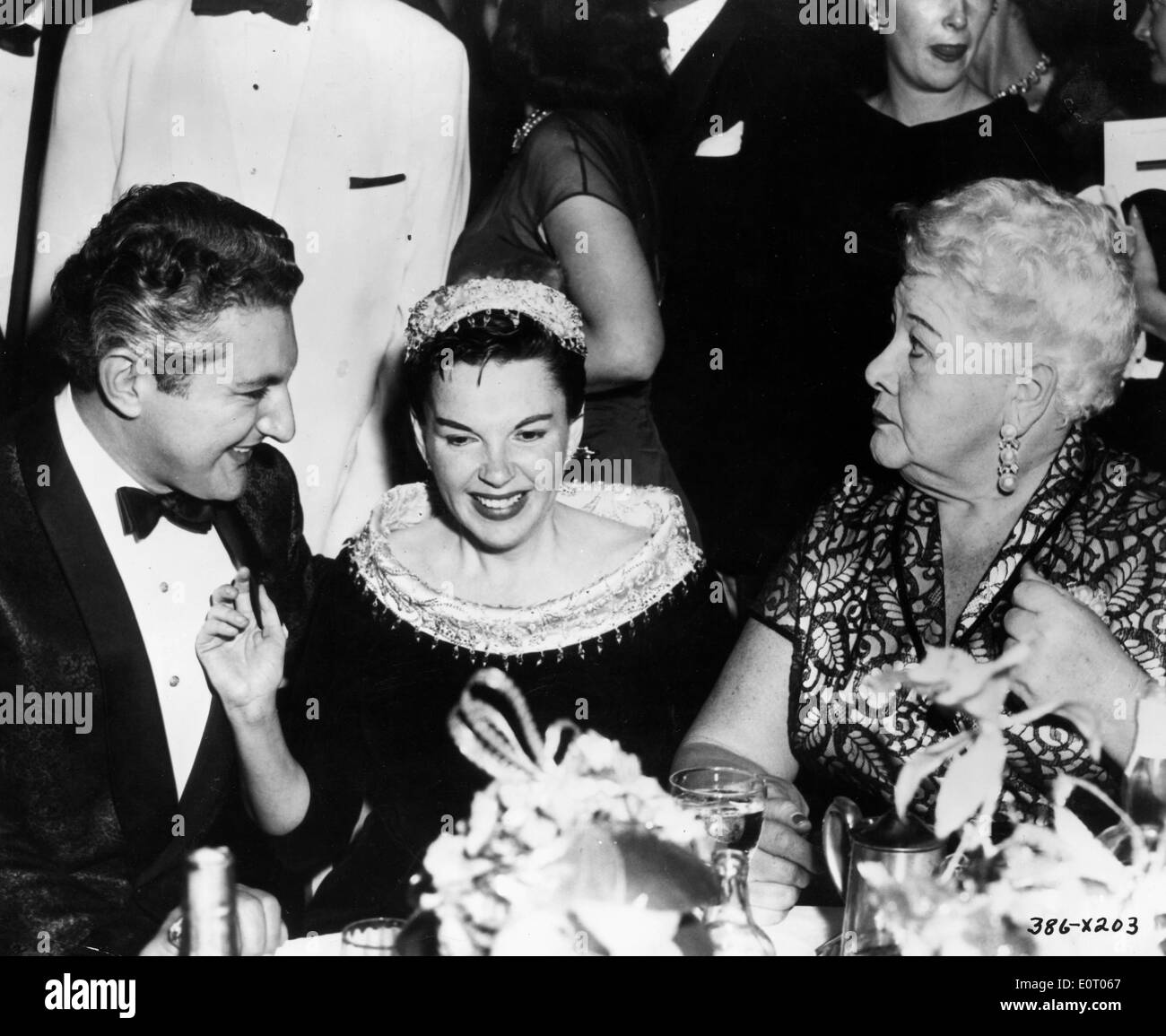 L'attrice Judy Garland risate con gli amici a una cena Foto Stock