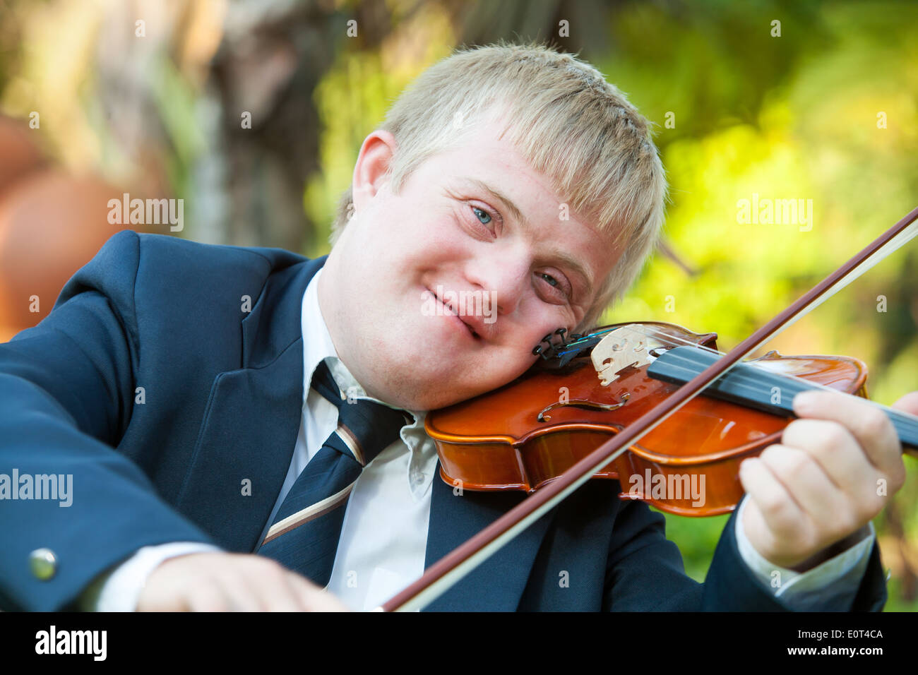 Ritratto di giovane violinista disabili la pratica all'esterno. Foto Stock