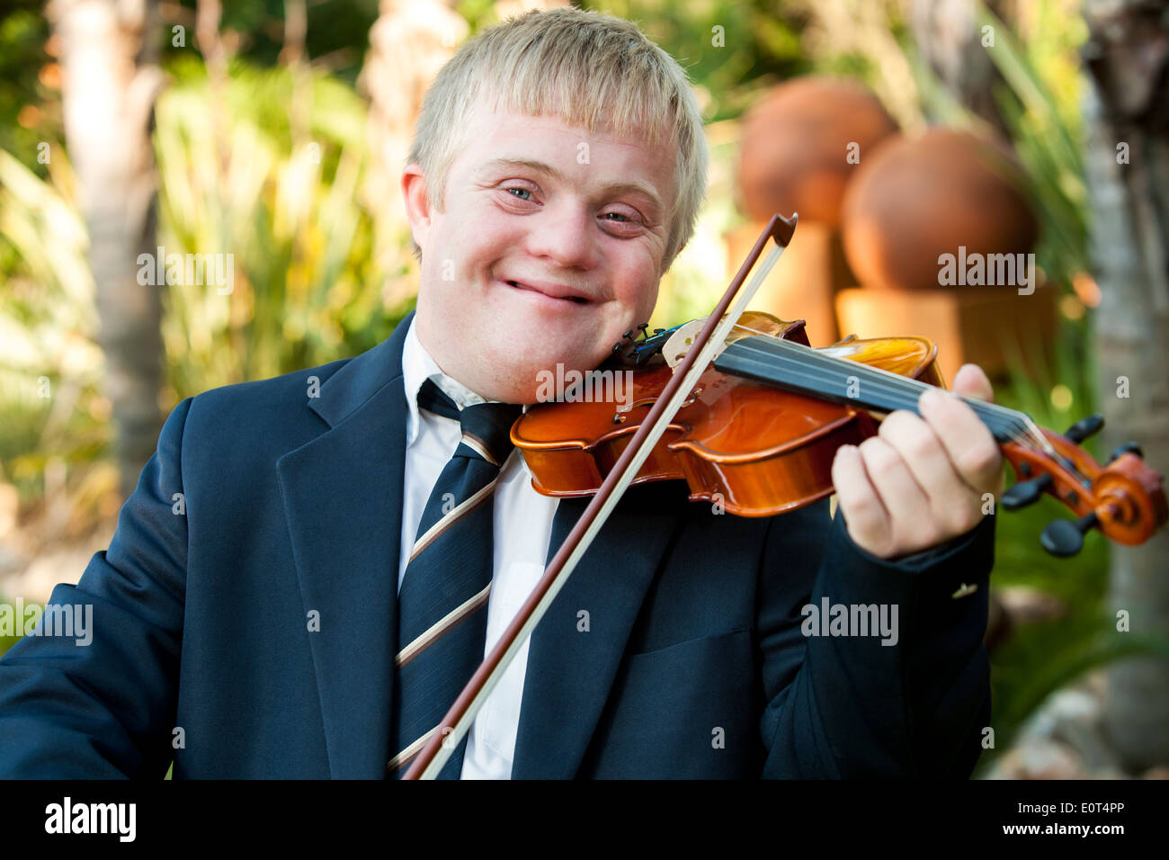 Close up ritratto di cordiale ragazzo disabile suona il violino all'esterno. Foto Stock