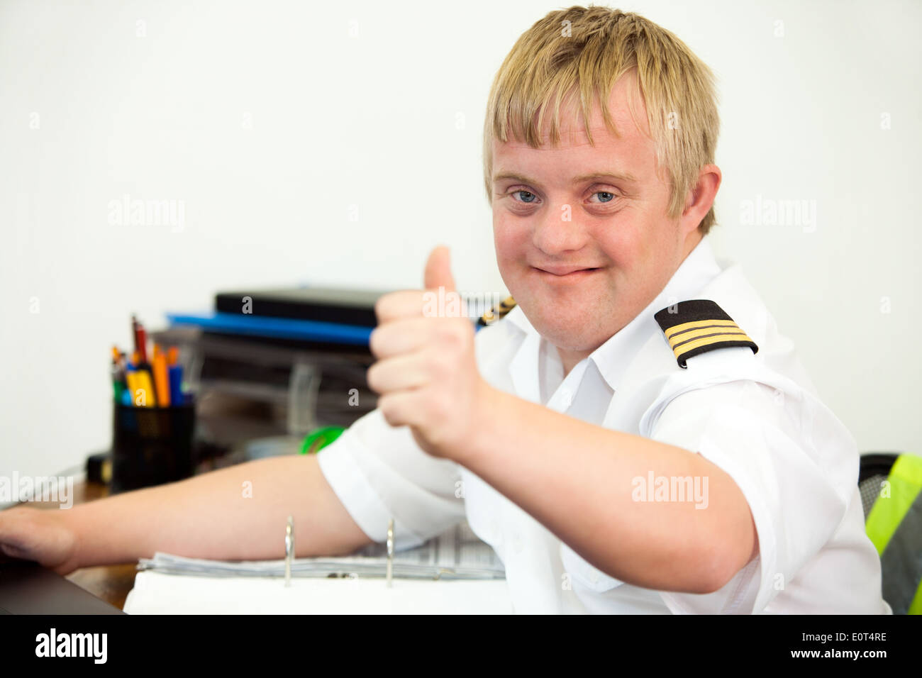 Giovane pilota disabile che mostra i pollici in su in ufficio. Foto Stock