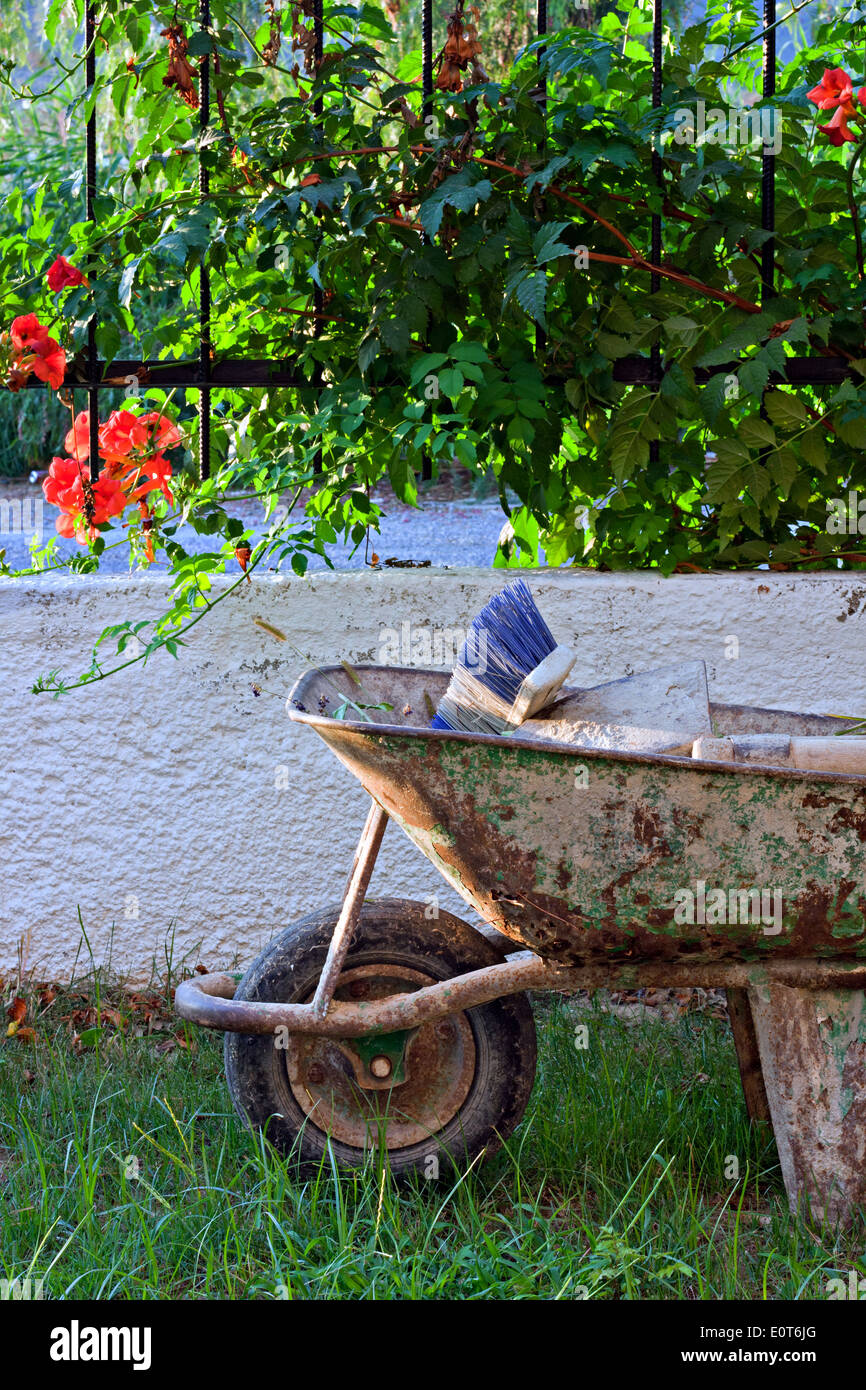 Utensili da giardinaggio in vecchia carriola arrugginita Foto Stock