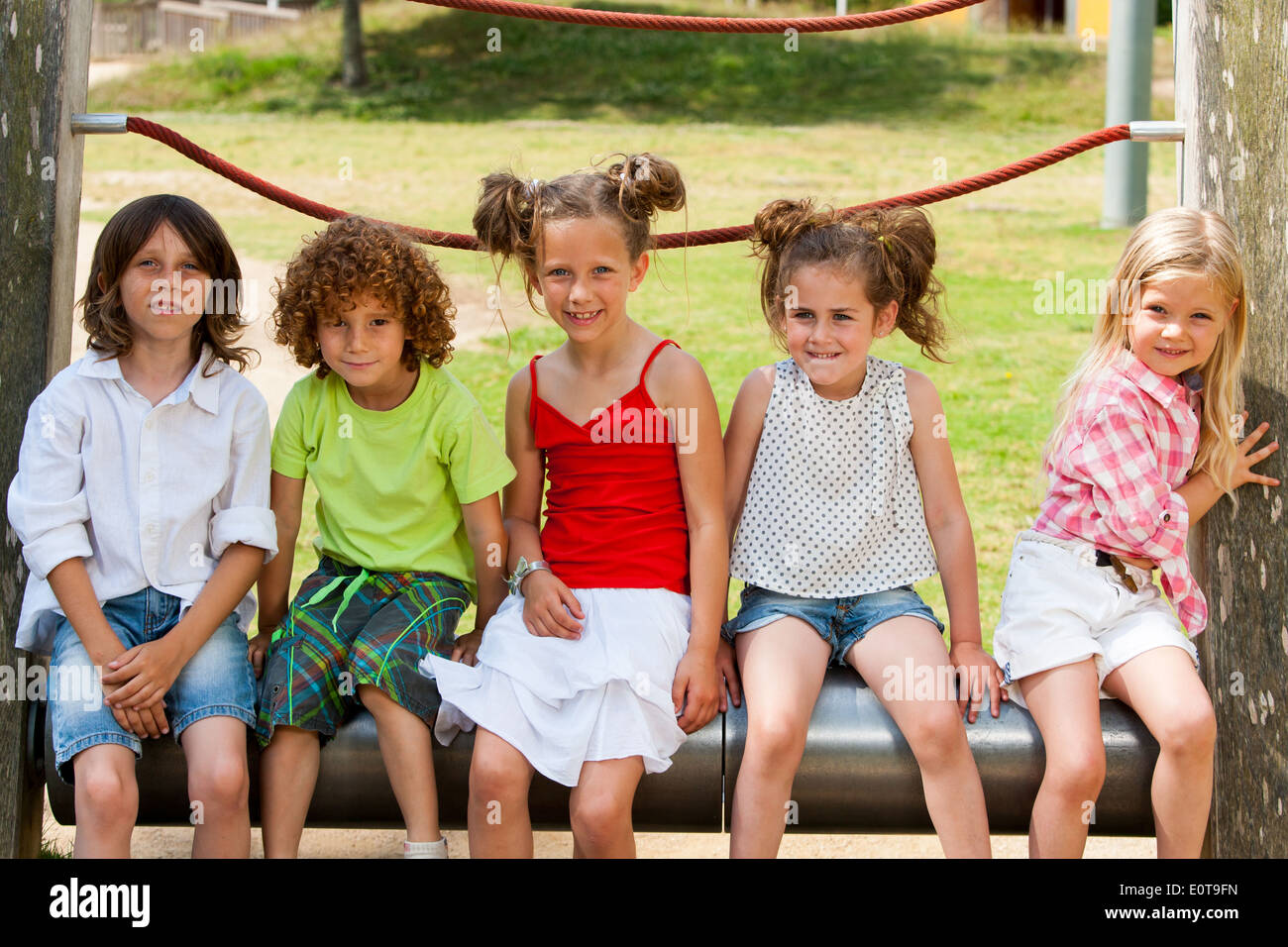 Bambini seduti insieme in posizione di parcheggio Foto Stock