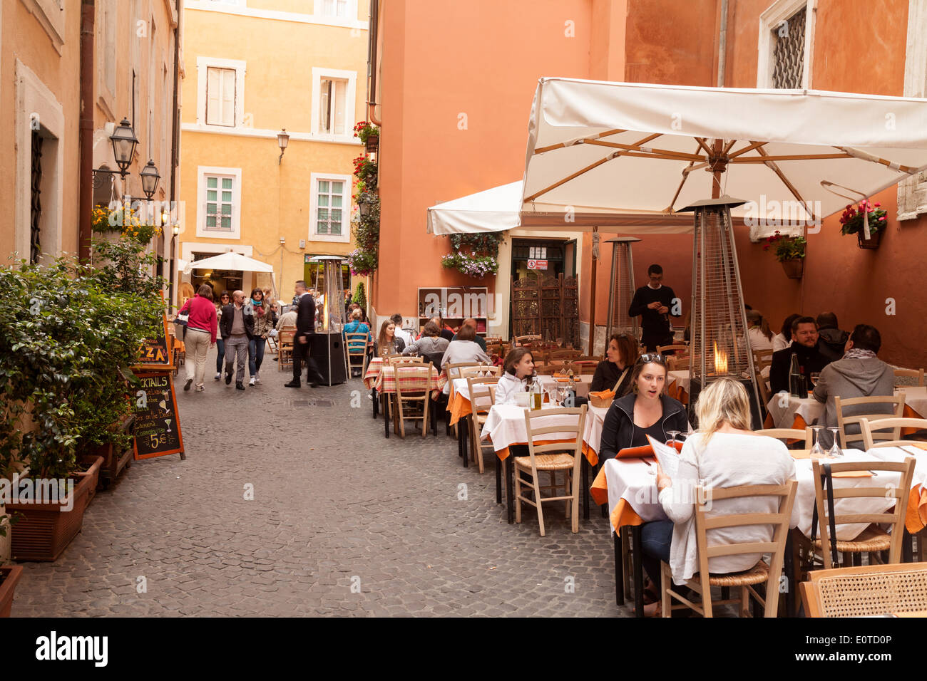 Persone bere e mangiare all'aperto presso una street cafe, Roma Italia Europa Foto Stock