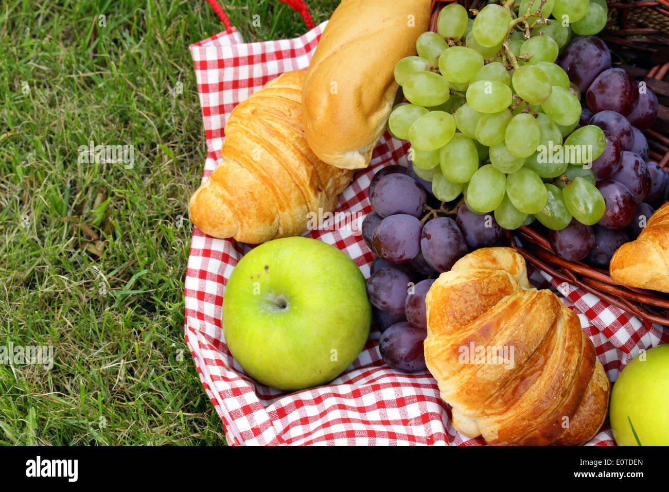 Pic nic sul prato verde con uve e croissant Foto Stock