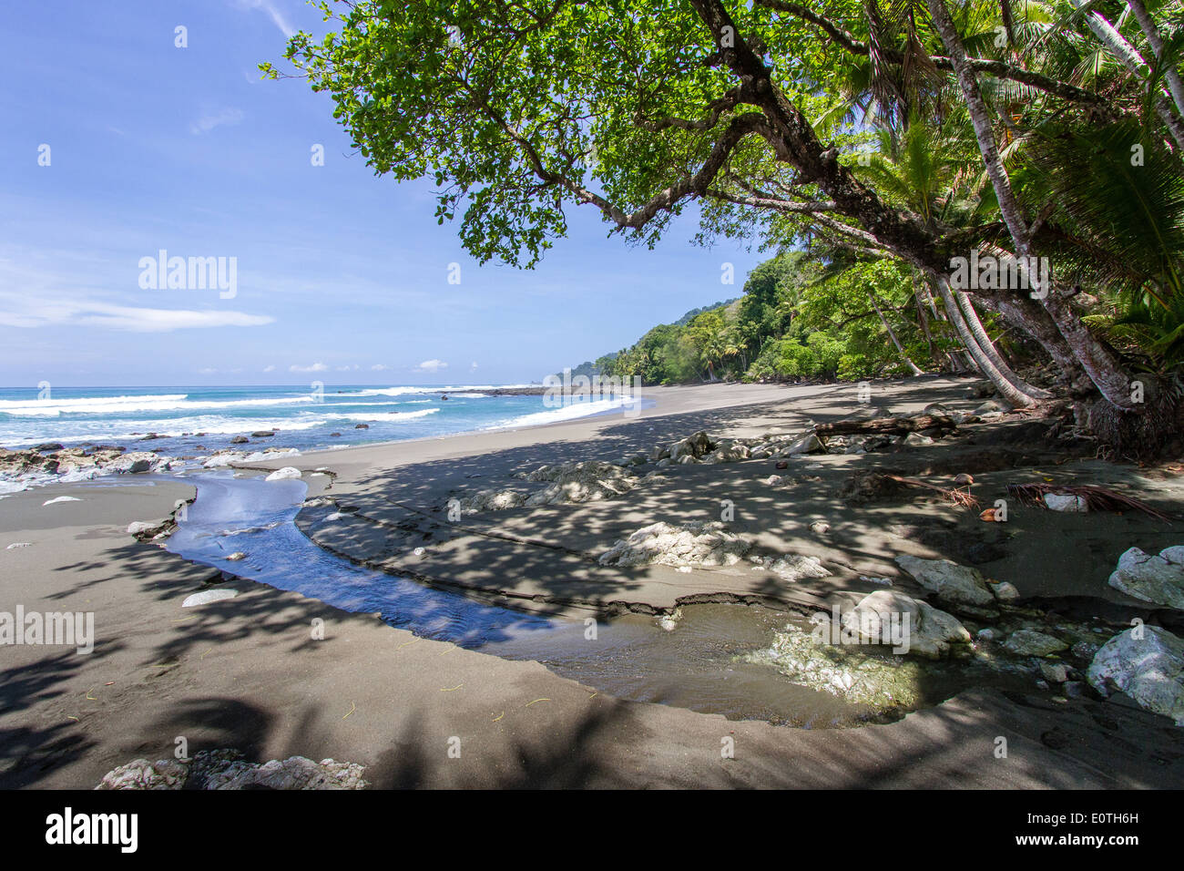 Piccola insenatura emergendo sulla Pacific Beach del Corcovado National Park in Costa Rica Foto Stock