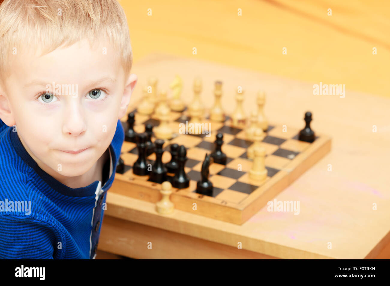 Infanzia. Intelligent smart bravo ragazzo bambino kid preschooler giocando a scacchi. Tempo libero. A casa. Foto Stock