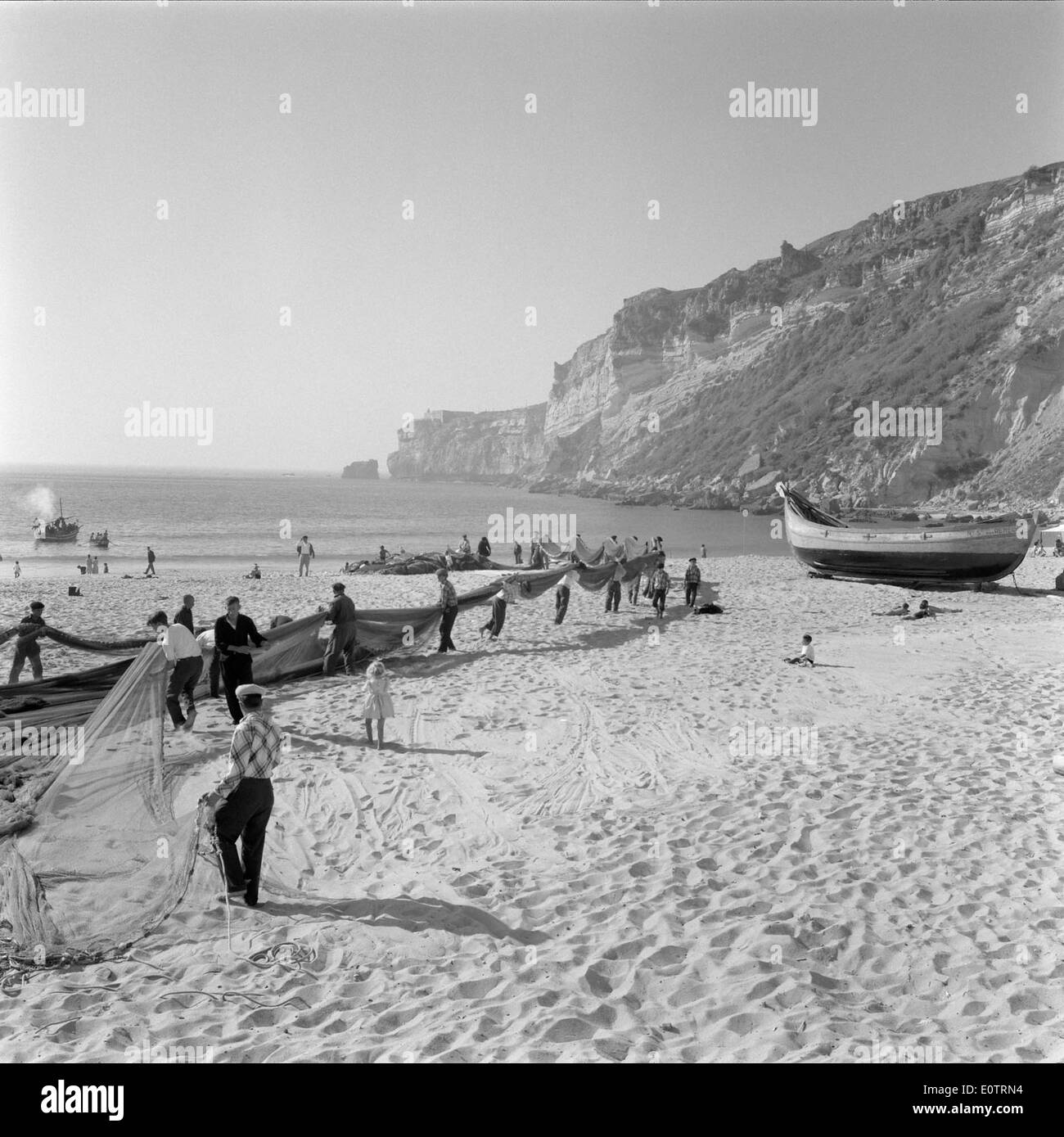 Le reti da pesca a Nazaré, in Portogallo, sono una parte vitale dell’economia marittima della regione. I pescatori locali si affidano a queste reti tradizionali per la cattura del pesce, riflettendo il rapporto di lunga data della città con il mare e il suo patrimonio ittico. Foto Stock