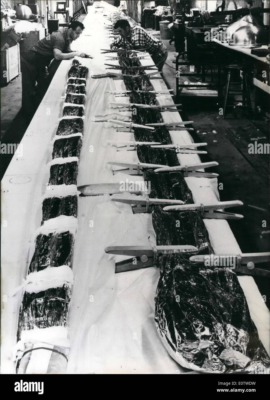 Agosto 08, 1960 - pioli di dimensioni astronomiche sono utilizzati presso il Langley Research Center della nazionale di Aeronautica e spazio Amministrazione. Qui, i tecnici stanno preparando due eco Progetto rivestito in alluminio satelliti di plastica. Sul tavolo da lavoro, ogni satellite è di poco più di 157 metri di lunghezza. Essi saranno compattamente ripiegato in metallo Contenitori payload 26 1/2 pollici di diametro. Il satellite a destra è nelle prime fasi di piegatura ed è tenuto in posizione da 12 pollici vestiti pin Foto Stock