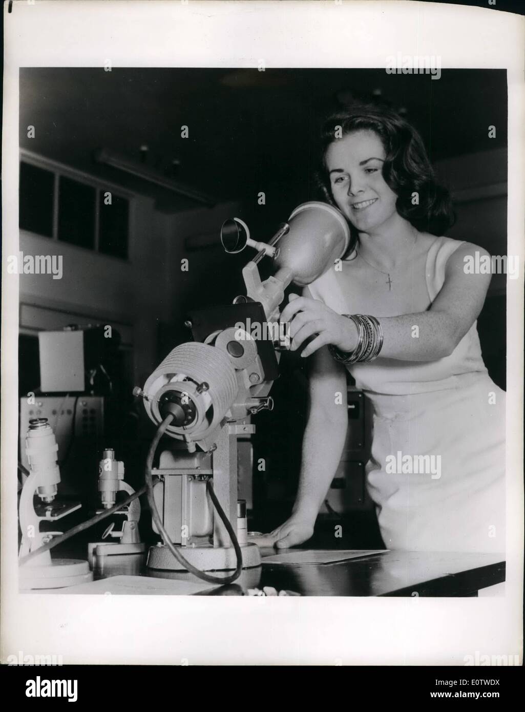 Agosto 08, 1960 - ragazza con una vista: uno studente presso la London University, Bernadette Heakin, prende il tempo fuori dallo studio per esaminare uno strumento che è un proiettore così come un microscopio. È stato mostrato in una fiera britannica di strumenti scientifici. Progettato da un'impresa britannica il microscopio è dotato di un trasformatore, il diaframma ad iride, triple di muso e la lente di condensatore. Se lo schermo è rimosso il microscopio può essere utilizzato per proiettare l'oggetto sulla diapositiva su uno schermo fino a sei metri di distanza. Foto Stock