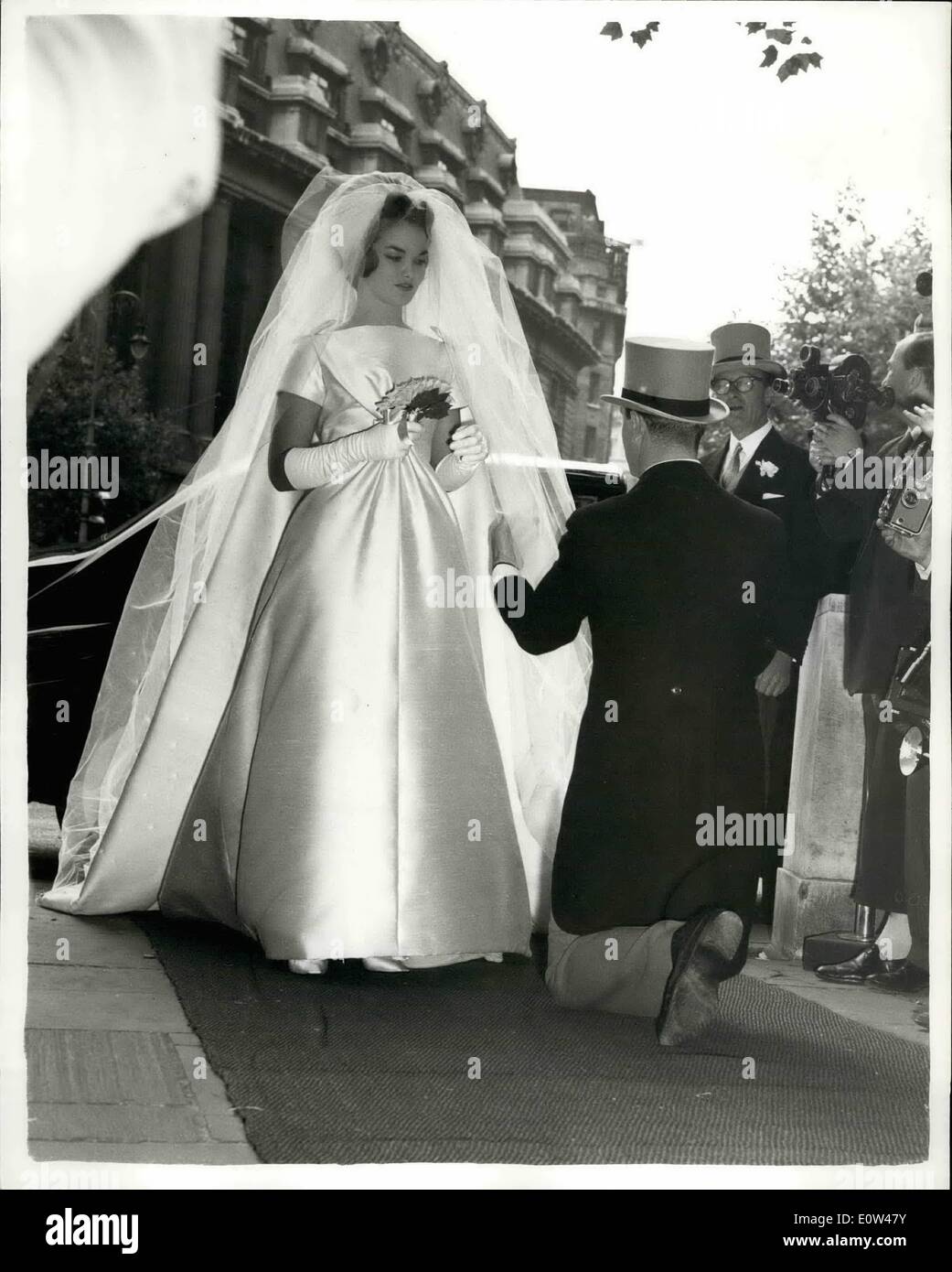 Giugno 06, 1961 - Nozze di Henrietta Tiarks al figlio del duca di Bedford: il matrimonio ha avuto luogo questo pomeriggio nella Basilica di San Clemente danesi, il filamento di Miss Henrietta Tiarks, figlia del sig. e della sig.ra Henry F. Tiarks ai Marchesi di Tavistock, sambuco, figlio del duca di Bedford. La foto mostra un comò dà un ultimo minuto verificare per la sposa del vestito come Ella entra nella chiesa. Foto Stock