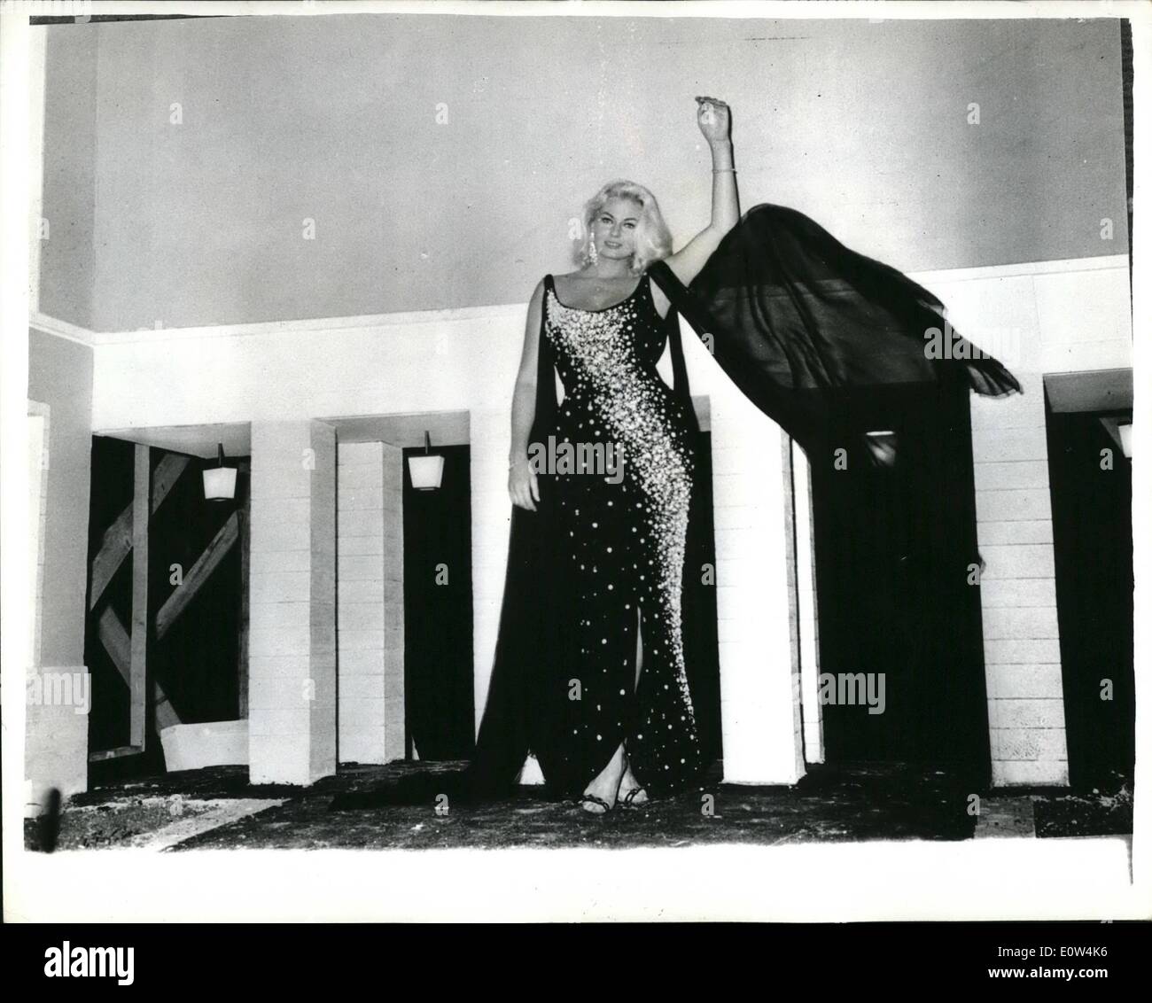 Giugno 06, 1961 - GULLIVER-TALL Anita Ekberg stelle nel film italiano Il più originale scone del film ''BOCCACCIO 70'' è stato girato a Roma all'inizio di questa settimana. La storia racconta del sogno di un uomo che vede-attrice svedese Anita Ekberg passeggiando Gulliver-simili intorno al suo distretto - che domina le case. Per questa sequenza del sogno, un intero quartiere di Roma è stata costruita in miniatura, foto mostra:Che cosa sembrano estremamente alte Miss EKBERG, ma è veramente una scala impostata Foto Stock