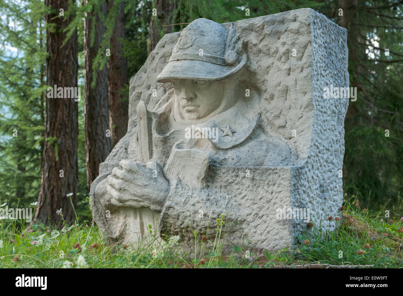 Monumento ai Caduti della Prima Guerra Mondiale, a bassorilievo in pietra di un soldato Alpini in posa eroica, lungo la strada per l'Ossario di Pocol Foto Stock