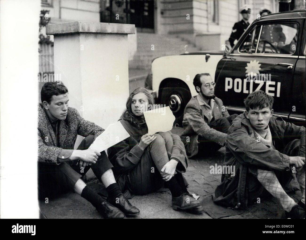 Apr. 24, 1962 - Sit-in sciopero di fronte al consolato USA di Amburgo.: 20 gli studenti svedesi ha iniziato a sit-in sciopero di fronte al consolato americano, a notte. Essi hanno espresso, in che modo la loro protesta contro la ripresa di energia atomica prove dagli americani. La polizia di Amburgo collocate alcune vetture prowl davanti al consolato, per evitare eventuali incidenti. La foto mostra gli studenti svedesi si aggirano tra le vetture di fronte al Consolato Americano di Amburgo. Foto Stock