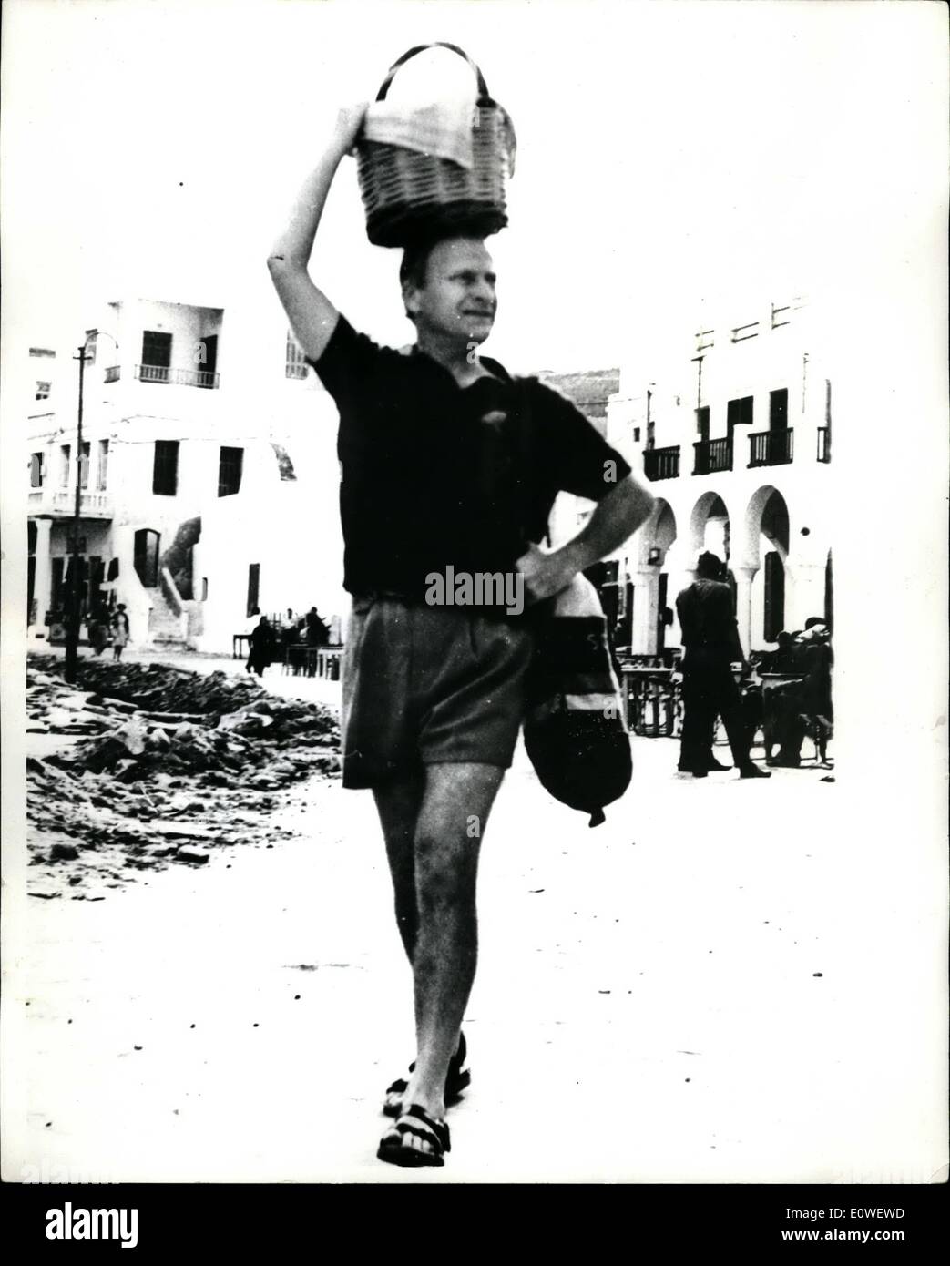 Ottobre 10, 1962 - Yehudi Menuhin in vacanza:il famoso violinista Yehudi Menuhin, in vacanza a Mikonos isola la costa greca, eseguito il suo carrello torna al suo albergo in un cestello sul suo capo il metodo di trasporto delle donne dell'isola. La foto mostra Yehudi Menuhin, in pantaloncini corti portato il suo shopping home. Foto Stock