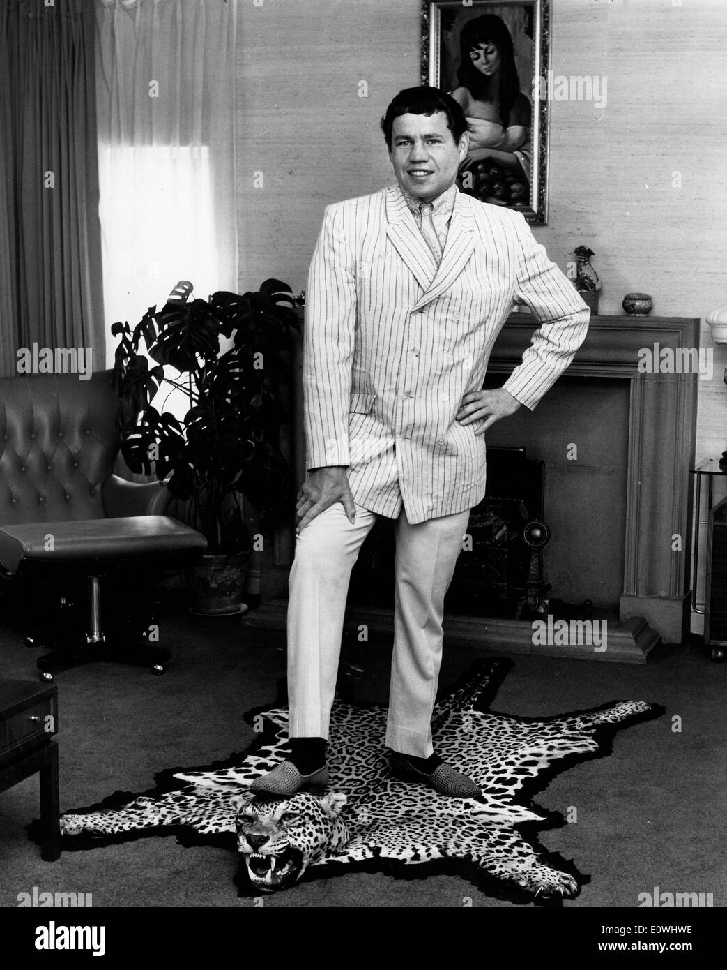 Boxer Terry Downes in piedi su un tappeto di leopard a casa sua Foto Stock