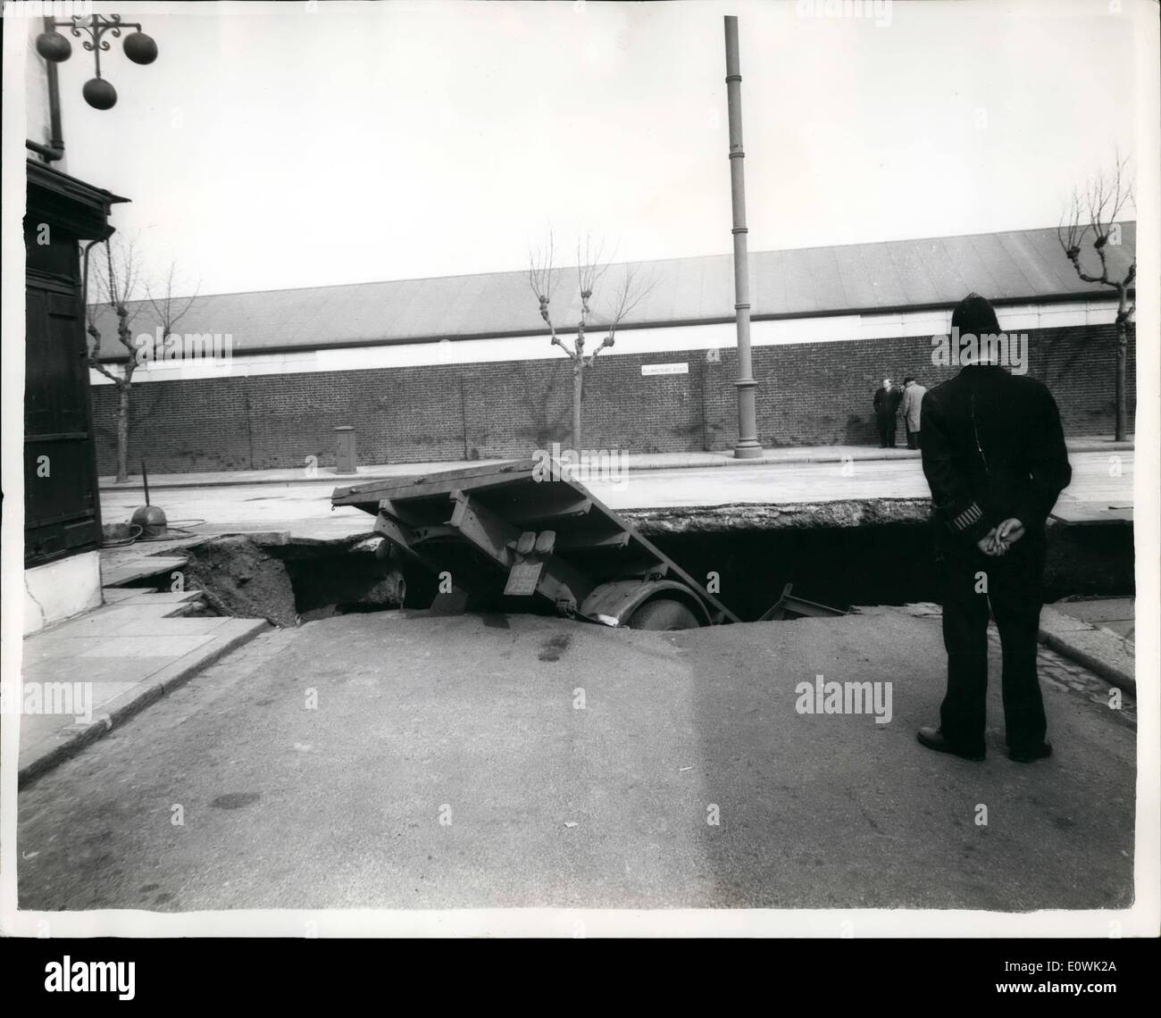 Apr. 04, 1963 - strada si apre fino a Woolwich e camion si blocca nel foro. Il giorno che la terra si aprì verso l'alto. Otto linee di autobus sono state deviate oggi dopo un camion si era schiantato in un foro che è comparso in carreggiata in Plumstead Road, Woolwich questa mattina. Il 22 enne driver è riuscito a passare dalla sua cabina come la strada è scomparso al di sotto di lui è rimasto illeso. La foto mostra il foro in strada come la coda del camion è tutto ciò che può essere visto dopo la caduta di questa mattina. Foto Stock