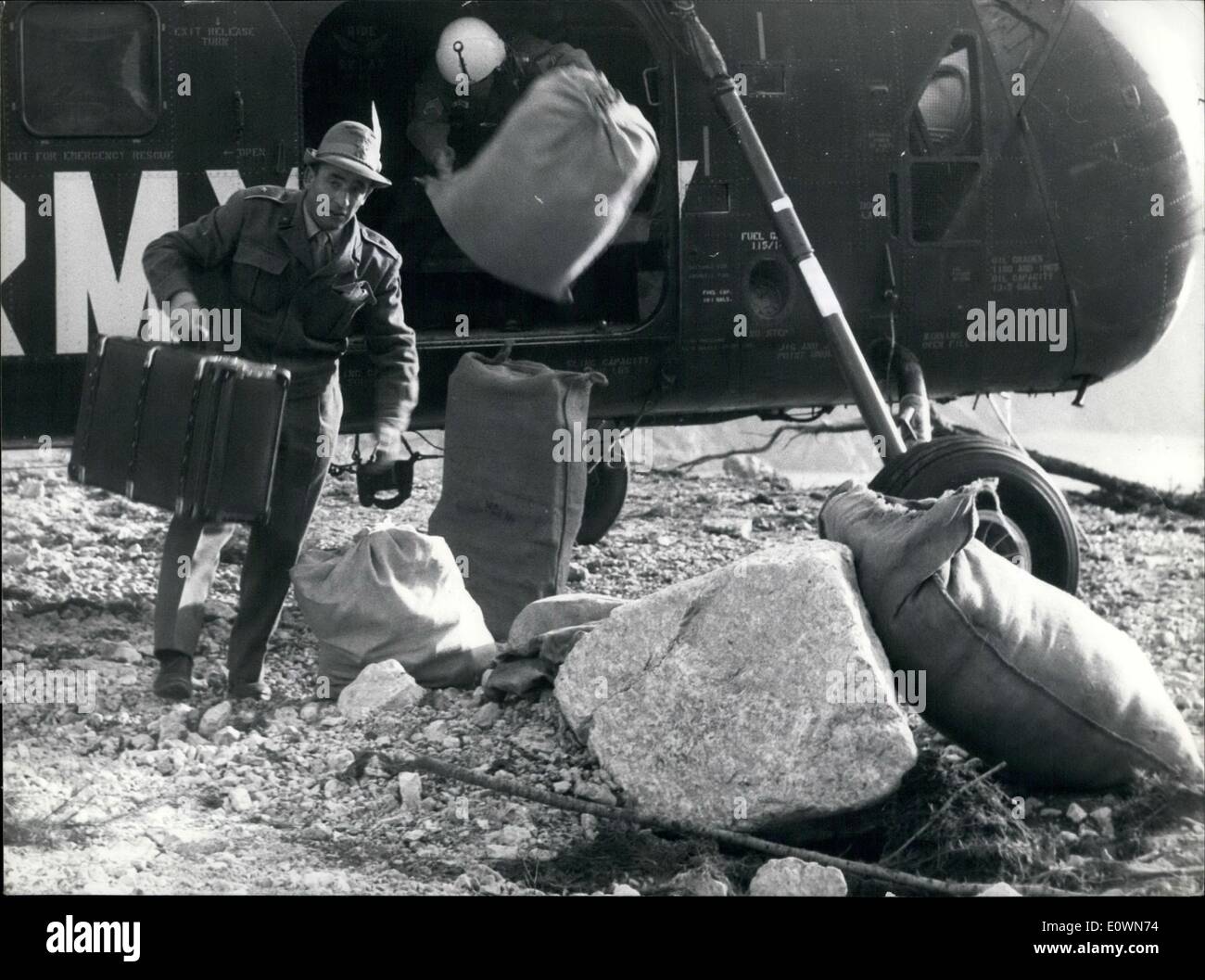 Ottobre 10, 1963 - pedaggio stimato: 3000 morti, Belluno, Nord Italia, 10.10.1963-un sacco con i vestiti sono gettati al di fuori di un US Army elicottero come un italiano soldato alpino affretta ad un gruppo di feriti sopravvissuti che ora sono trasportati da ambulanze nelle vicinanze di ospedali. Foto Stock