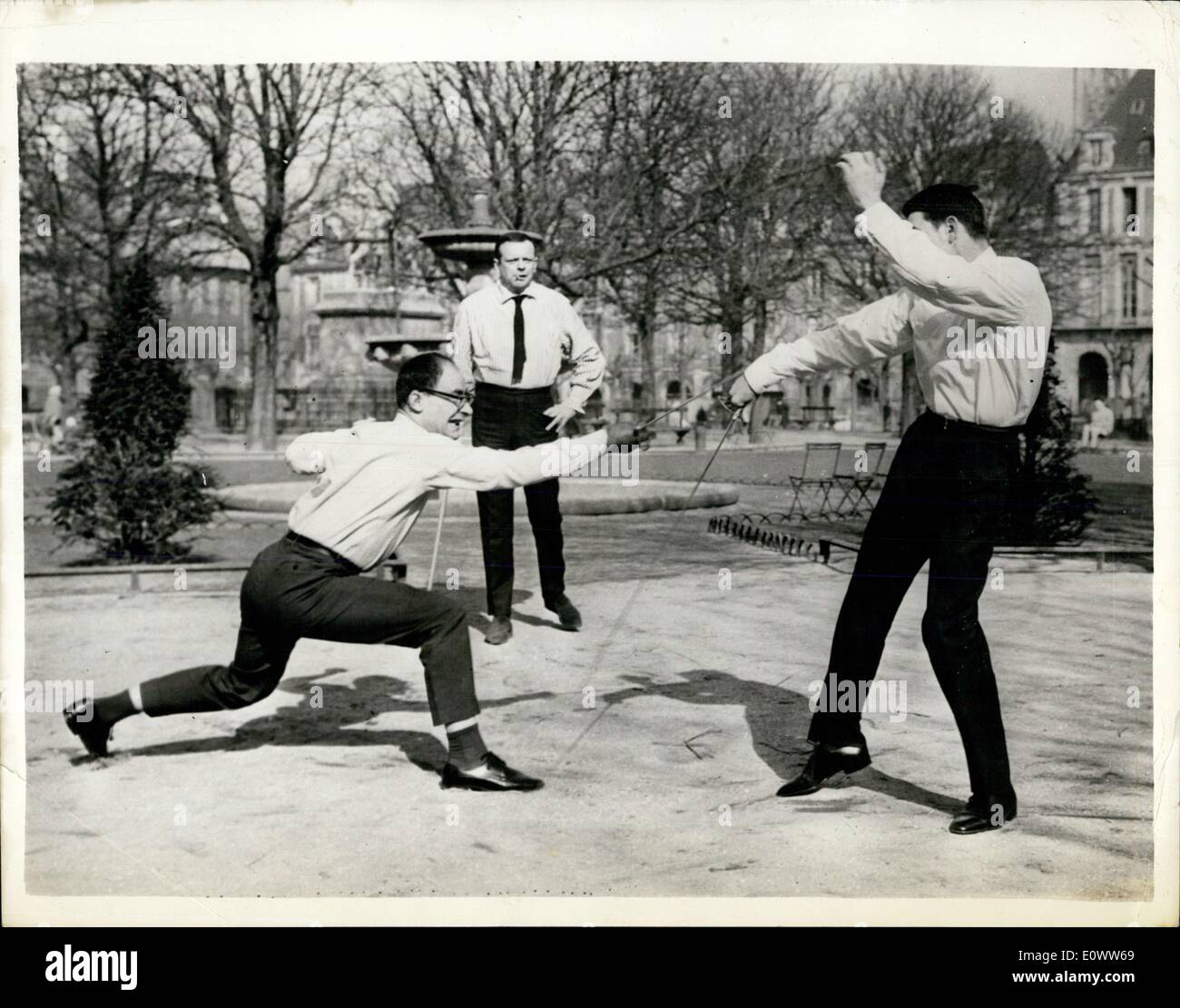 Mar 11, 1964 - Giornalisti duello - su un libro: a Parigi questa mattina, due giornalisti, Monsieur Eskanazy e Monsieur Mordacq combattuto un duello in place des Vosges. Il erano in disaccordo su un libro scritto su Leon Daudet, un fascista francese degli anni trenta. Il duello ebbe fine quando Monsieur Moedacq fu ferito sul lato destro dai suoi avversari di spada di fanteria. Mostra immagine: la scena durante il duello, M. Eskanazy è sulla sinistra, M. Mordacq è destra, guardato dal master a bracci. Foto Stock