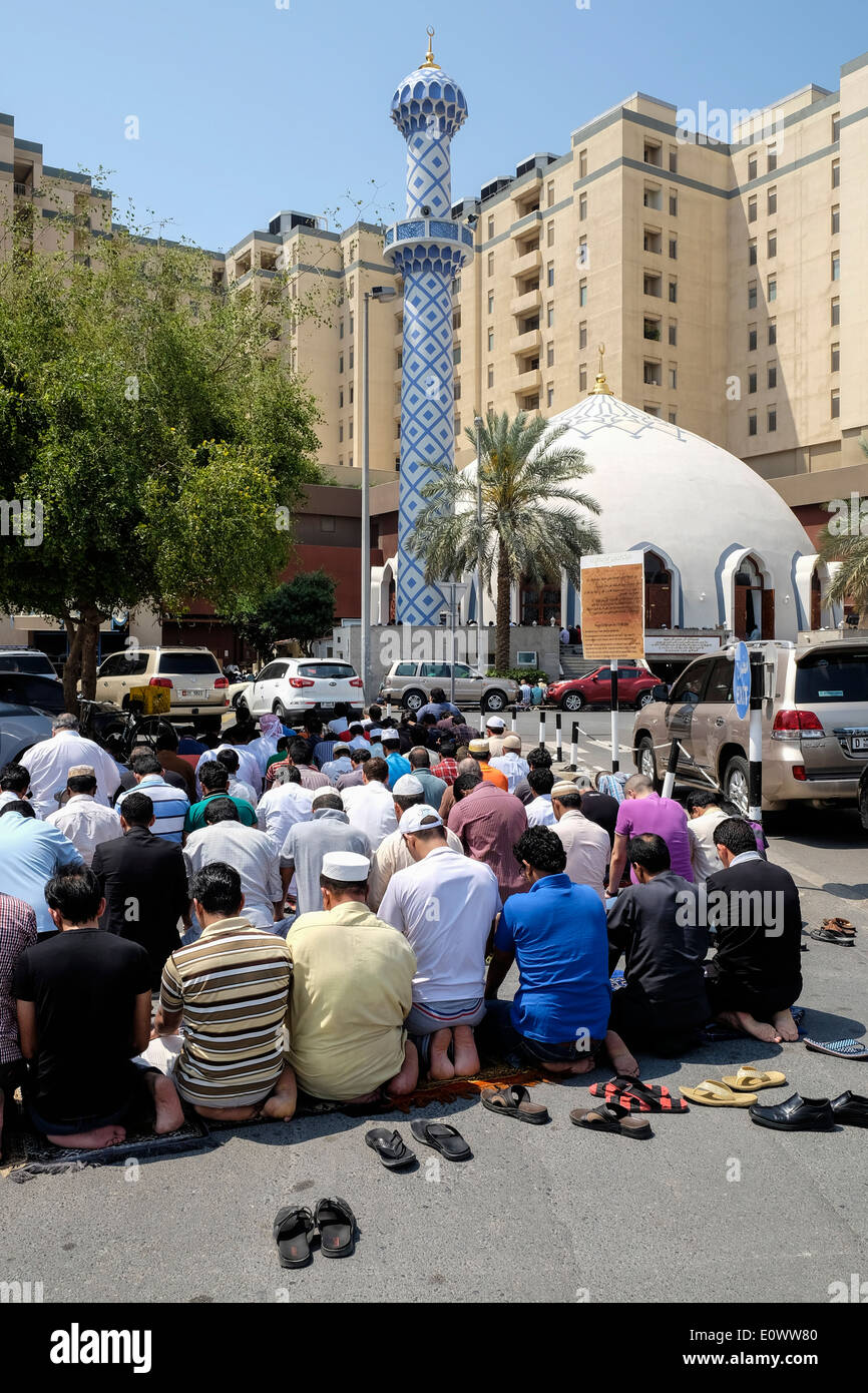 Molti uomini la preghiera del venerdì al di fuori Moschea, presso il centro commerciale di Burjuman in Dubai Emirati Arabi Uniti Foto Stock