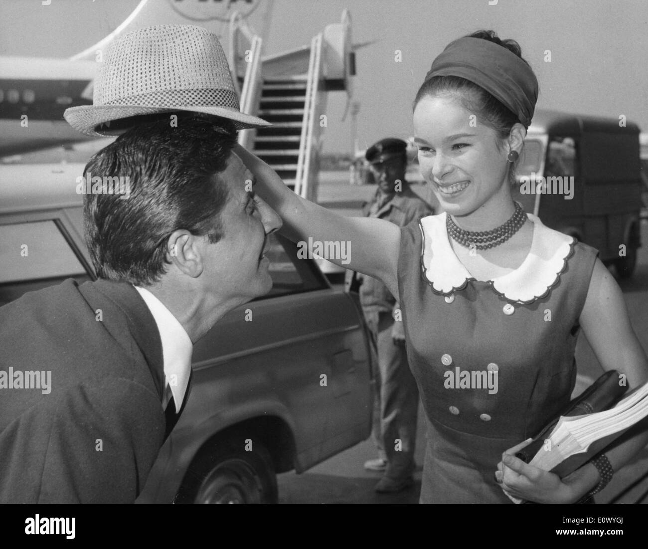 Luglio 3, 1964 - Parigi, Francia - ballerina e attrice GERALDINE CHAPLIN divertirsi con l'attore Gilbert Becaud prima di salire a bordo del loro piano di Bal des Petits Lits Blancs all'aeroporto di Orly. Foto Stock