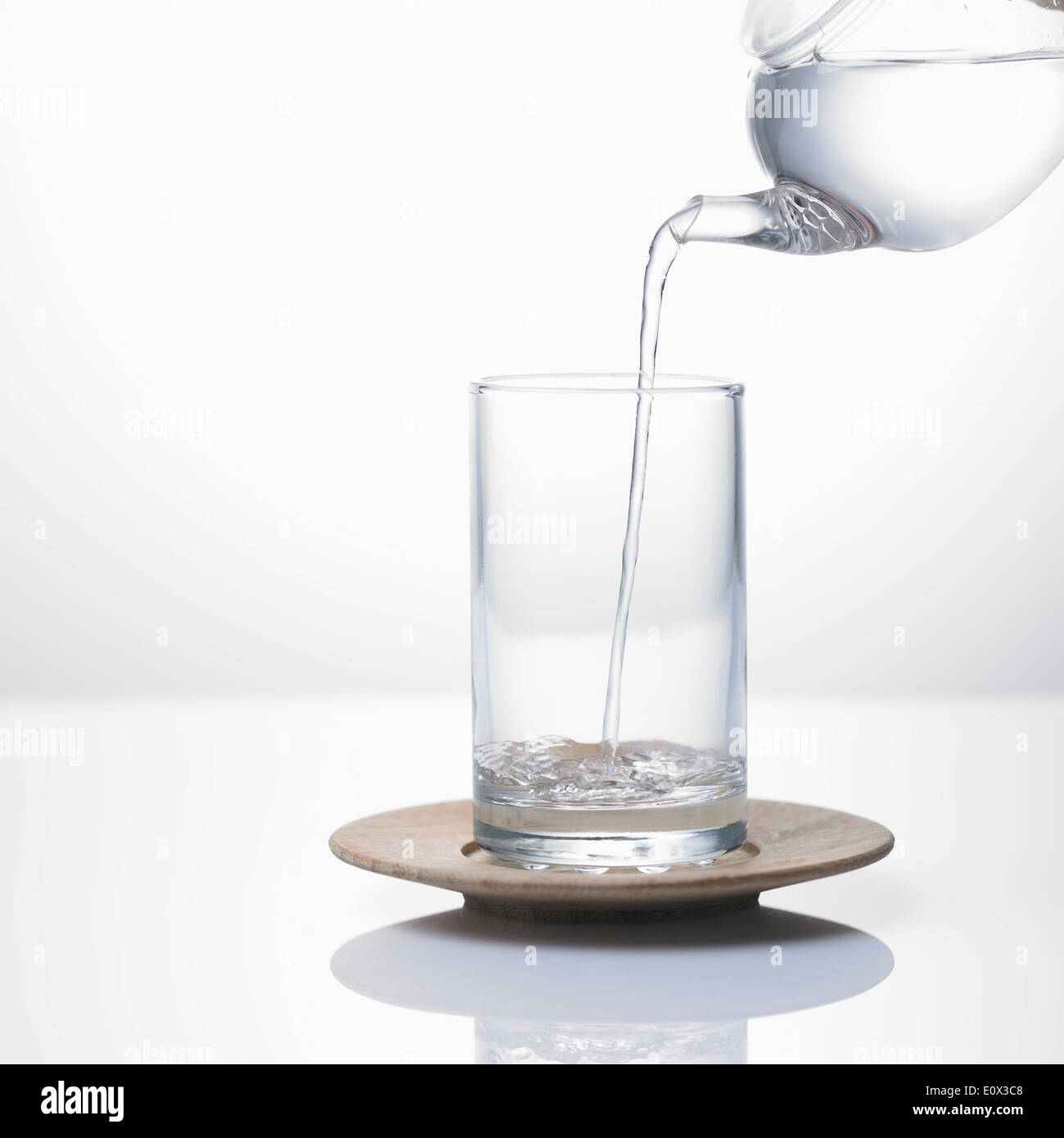 L'acqua versata da una pentola ad un vetro Foto Stock