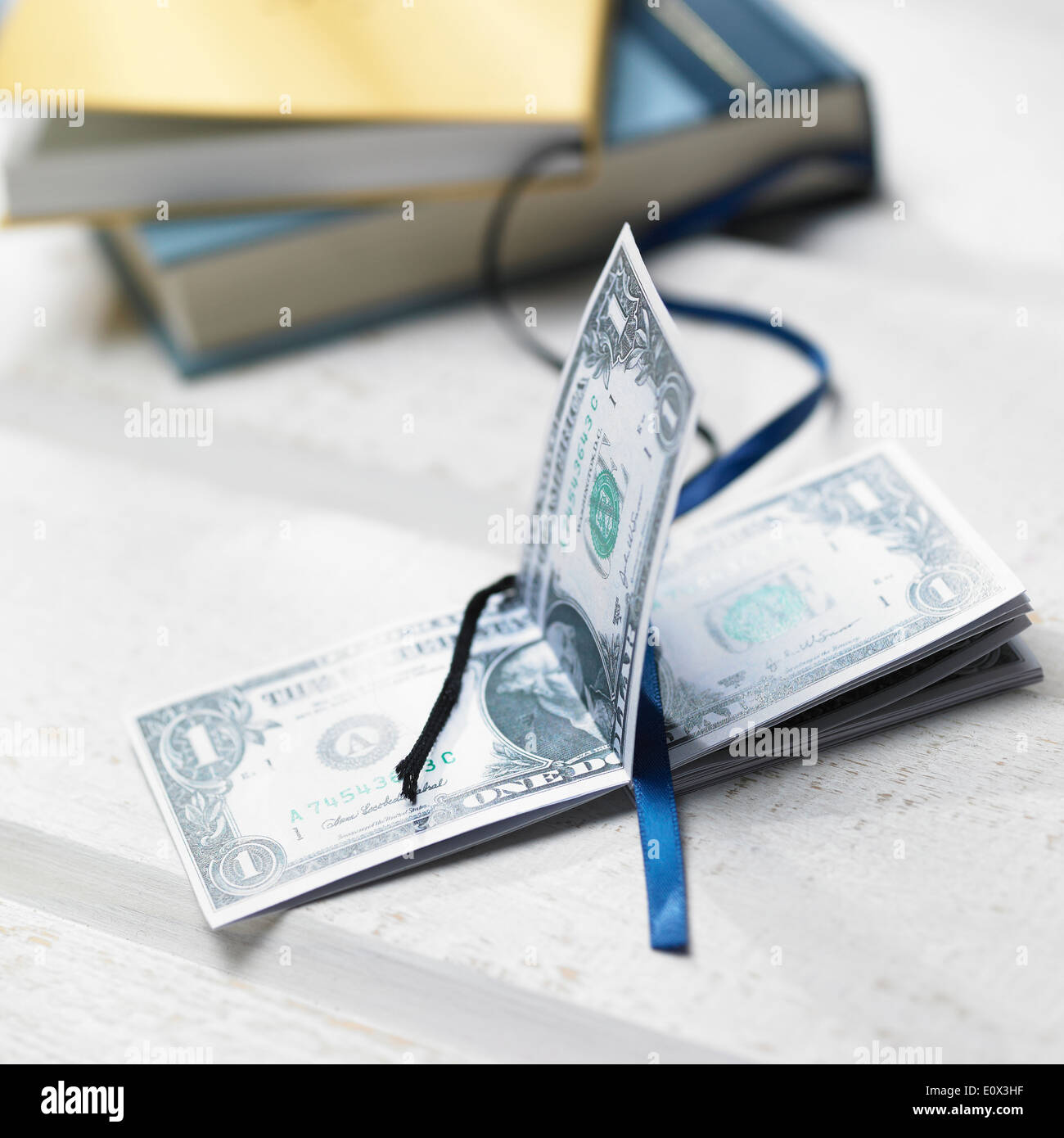 Un mucchio di soldi accanto ai libri Foto Stock