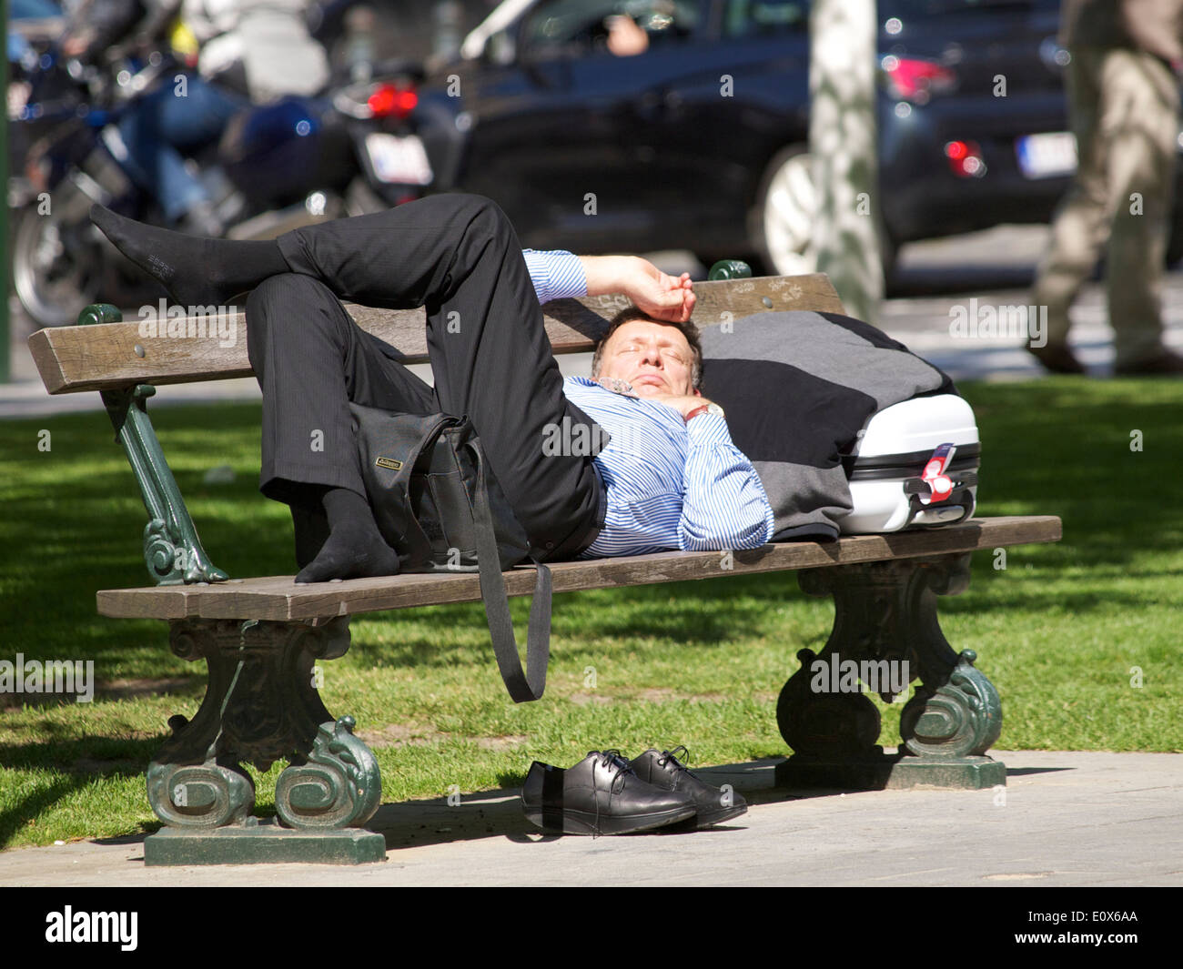 Business Traveller relax al sole su una panchina nel parco di Bruxelles in Belgio Foto Stock