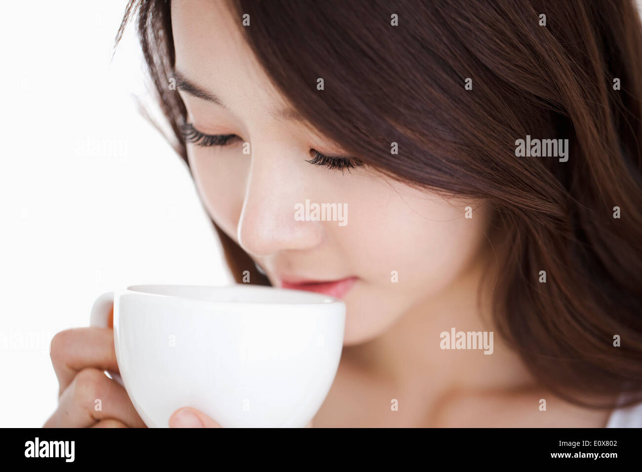 Una donna di bere da un bicchiere di bianco Foto Stock