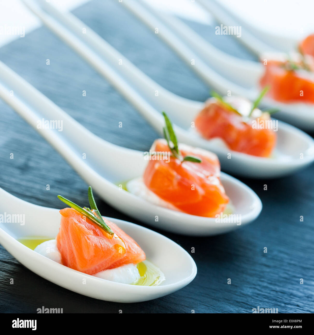 Numerosi cucchiai di porcellana con salmone affumicato bocconcini. Foto Stock