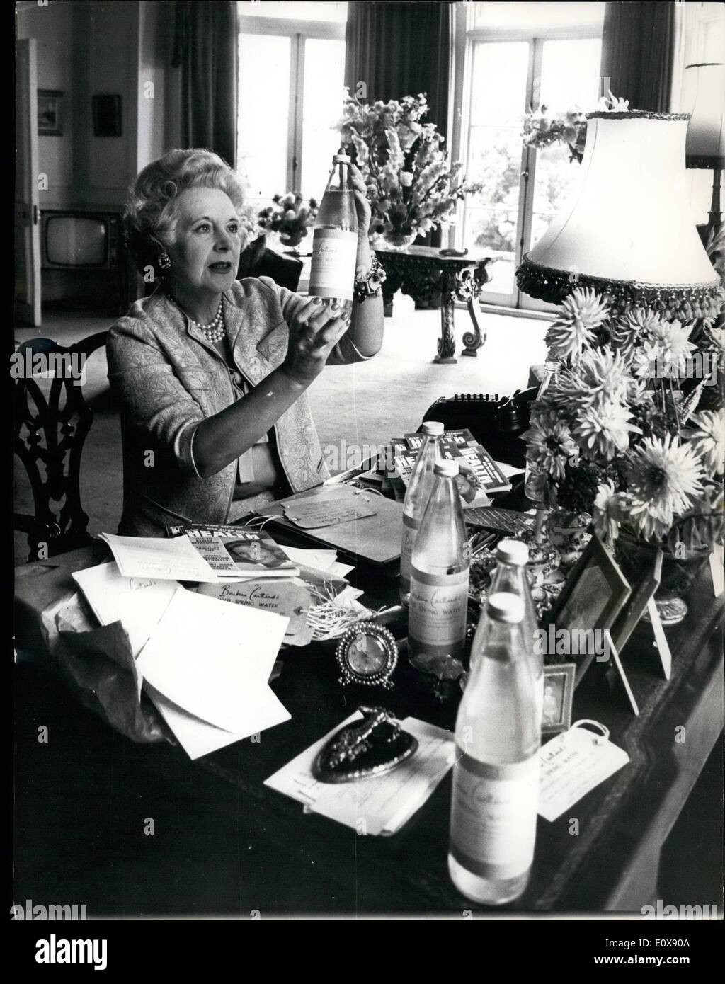 08 agosto 1965 - Barbara Cartland purvey di acqua pura.: L'esercito romano, ha detto Barbara Cartland fermamente, ha pensato molto molto alla sua acqua di sorgente selvaggia. In volata, sono stati i Romani a sfruttare per la prima volta la primavera su cui ora si affida per l'acqua pura che spera di vendere a 10d. Una bottiglia. Ha detto la signorina Cartland: Hanno fatto molto bene senza sostanze chimiche artificiali nella loro acqua. "Si riferiva naturalmente a una minaccia che la implorava di trasformare il suo -arder in un impianto di imbottigliamento per acqua pura. Ma il commercio è sul lato lento nella sua casa, Camfield Place, Essendon, Herts Foto Stock