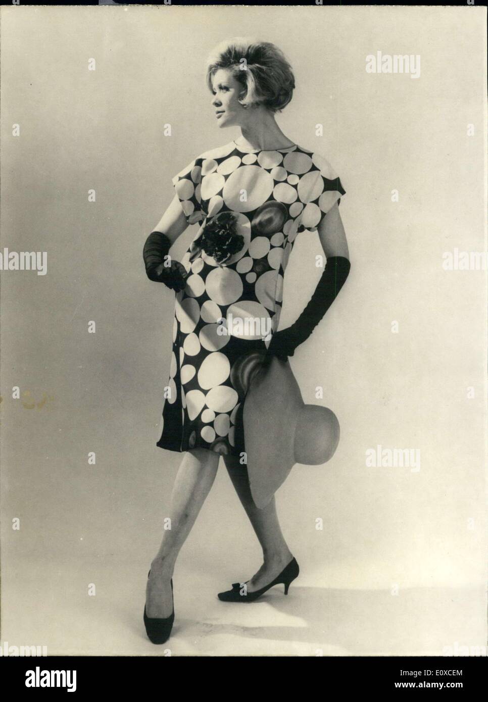 Giugno 04, 1966 - sapore parigino: per cocktail party, abito parigino designer Jacques Launay ha creato questa sura abito con grande seppia e cielo blu dots provenienti su nero. Il vestito è decorato con un fiore realizzato nello stesso materiale. La foto mostra un modello presenta l'abito da cocktail. Foto Stock