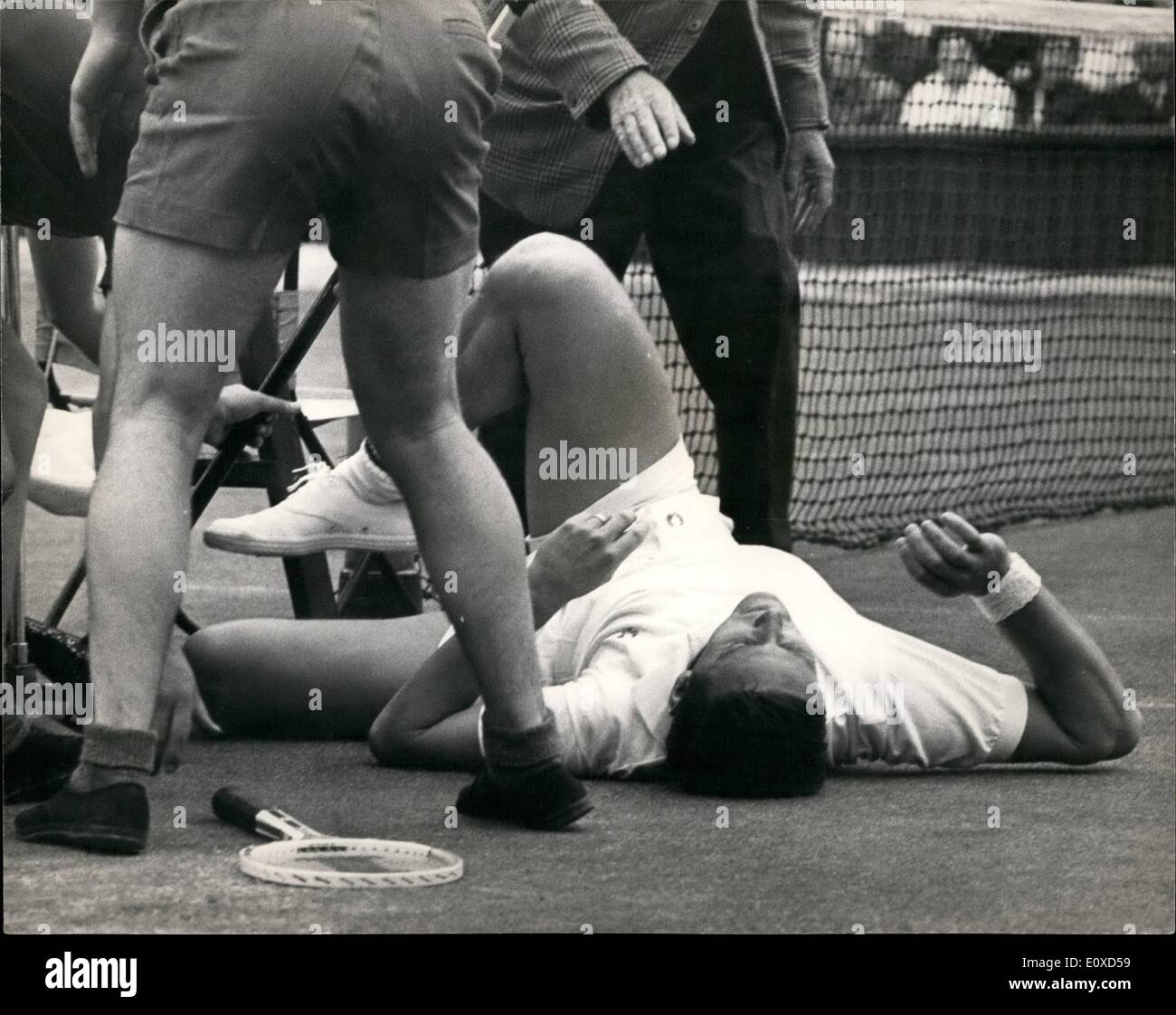 Giugno 06, 1966 - sensazione a Wimbledon. Roy Emerson battuto: durante la sua partita contro il compagno australiano, O.K. Davidson, Roy Emerson, il No.1 seme, in fretta il net per restituire un colpo, scivolato e rimasta intrappolata con micro telefono, palla ragazzo e arbitro stand. Il suo avversario si precipitò per vedere se lui è rimasto ferito e dopo pochi minuti era in grado di giocare di nuovo. Dopo la partita, nel desiderio di Emerson è stato picchiato, egli è andato in ospedale per un check-up. Foto mostra Roy Emerson raffigurata sul terreno dopo egli rimasta intrappolata dopo correndo per il net per il ritorno di uno shot. Foto Stock