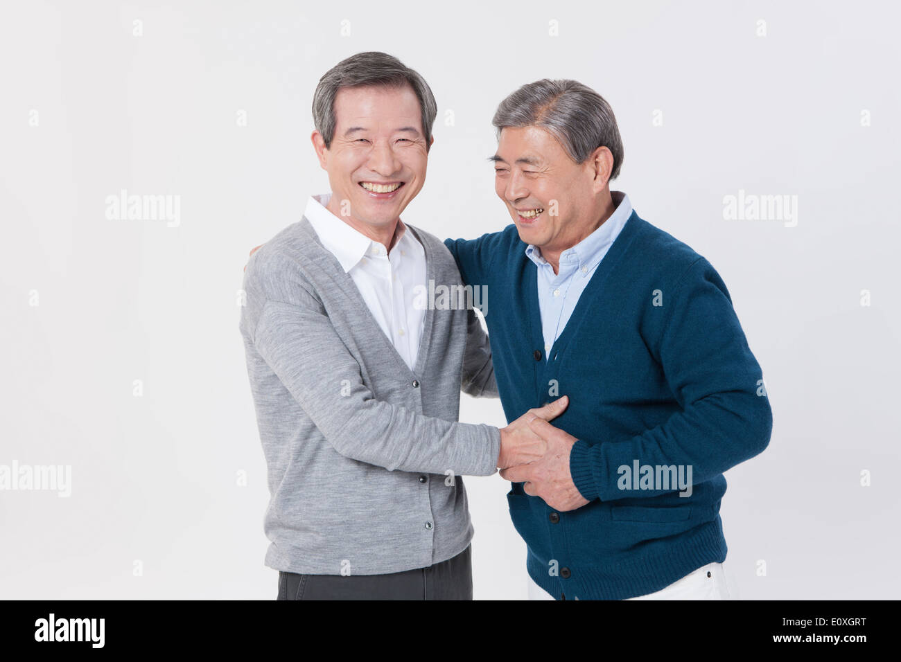 Due vecchi uomini stringono le mani Foto Stock