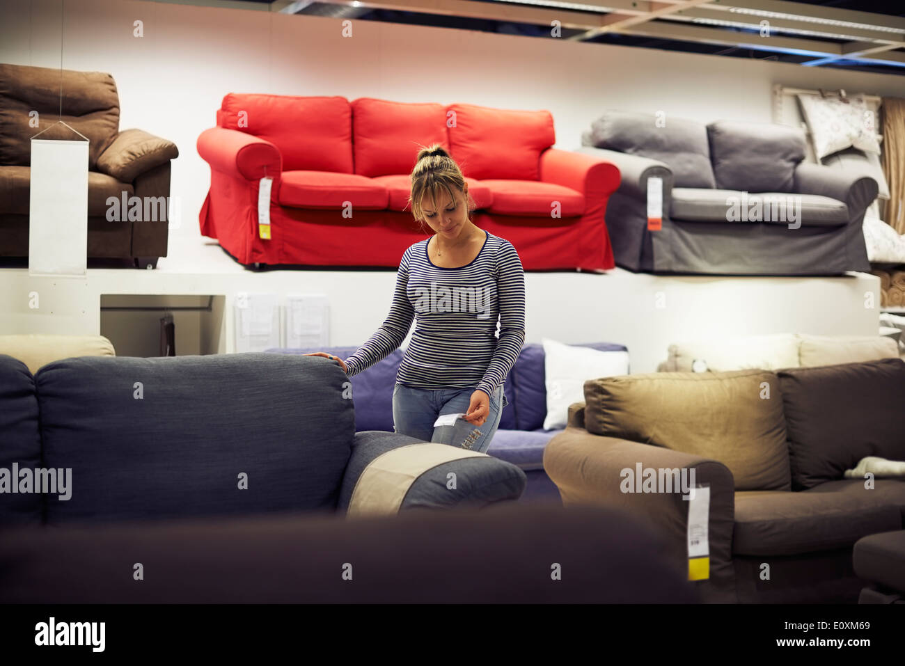Giovane donna ispanica shopping per mobili, divano e home decor in negozio Foto Stock