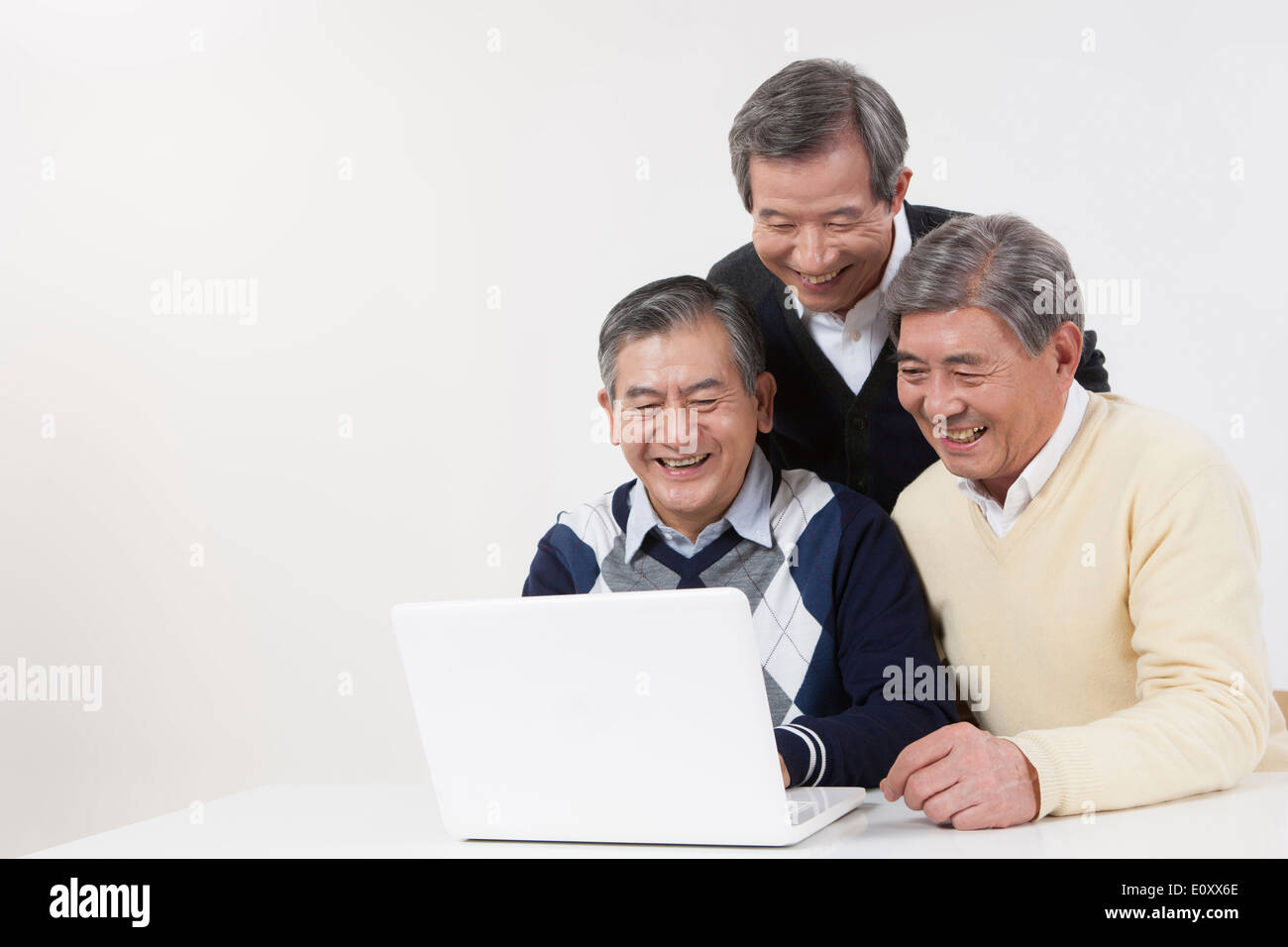 Vecchie persone che lavorano con un computer portatile Foto Stock
