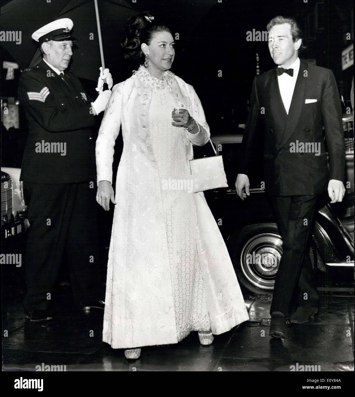 Apr. 15, 1969 - Teatro Regio visita: la principessa Margaret, protetto dalla pioggia da un grande ombrellone, cavallerescamente detenute da un portiere, arriva al Prince of Wales Theatre con Lord Snowdon (a destra), per una performance di beneficenza della commedia ''Cat tra i piccioni''. La performance è stata in aiuto della National Youth Theatre, di cui Lord Snowdon è Patrono. Foto Stock