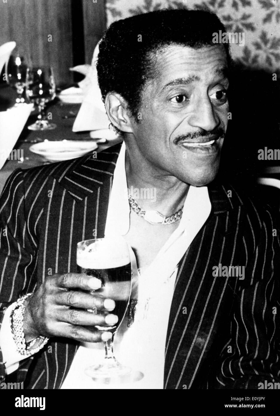 Il cantante Sammy Davis Jr. gode di una bevanda Foto Stock