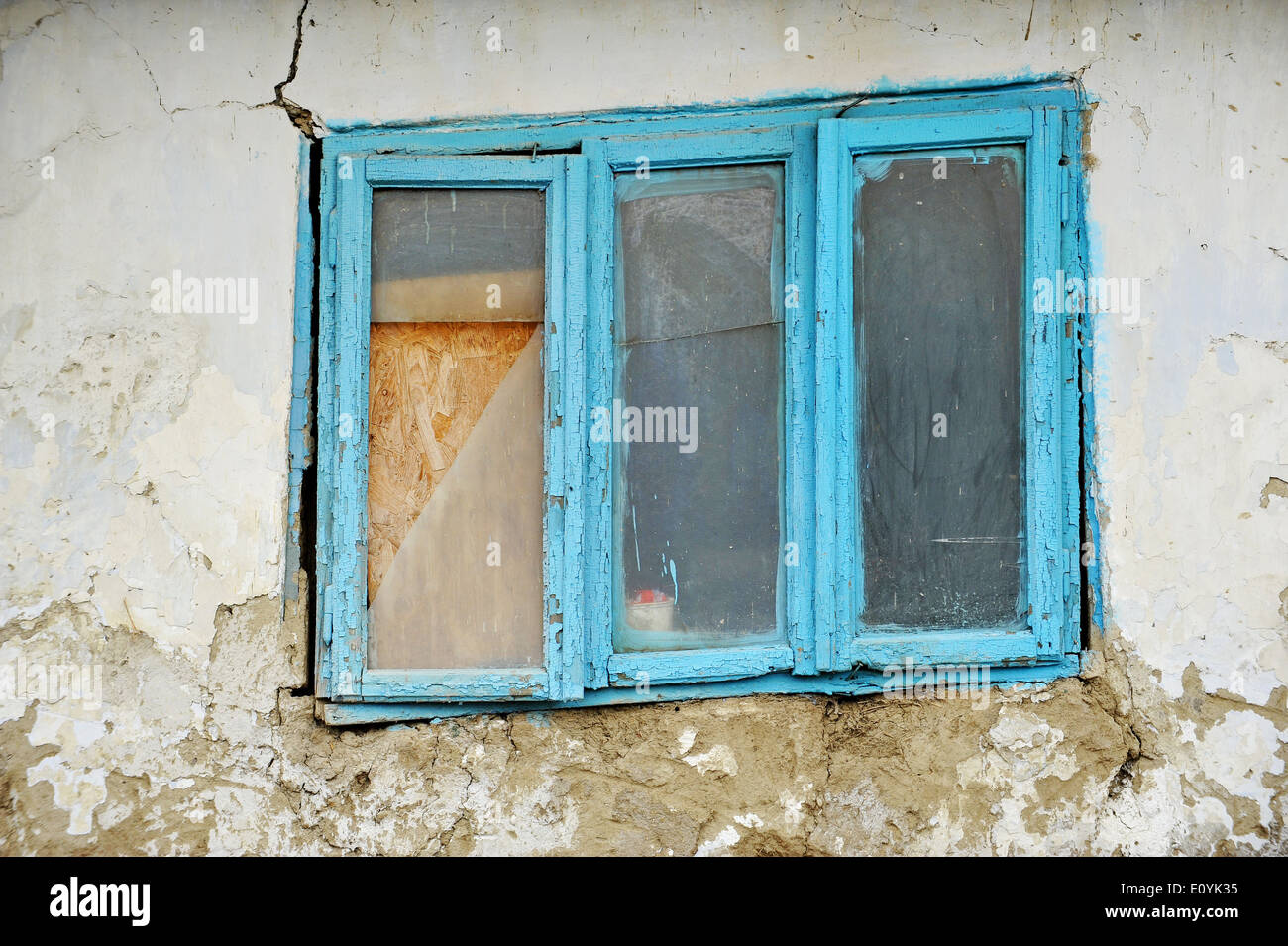 Danneggiato tradizionale vecchio adobe house dettaglio con finestra blu Foto Stock