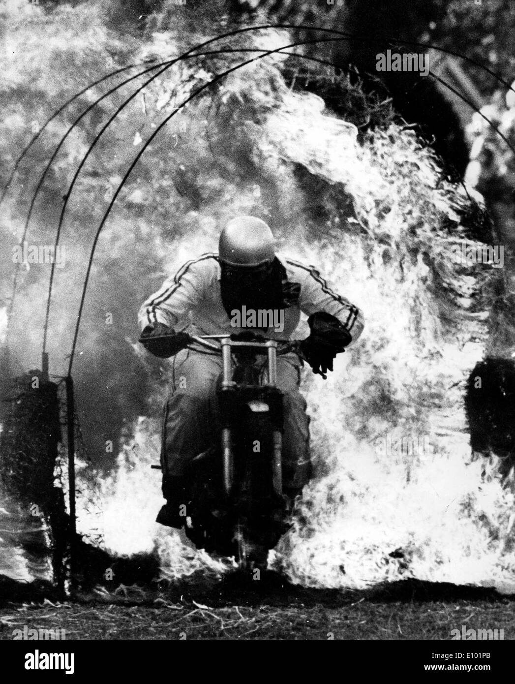 DAVID BLAKER cavalca un motociclo tramite fiamme durante un incendio stunt Foto Stock