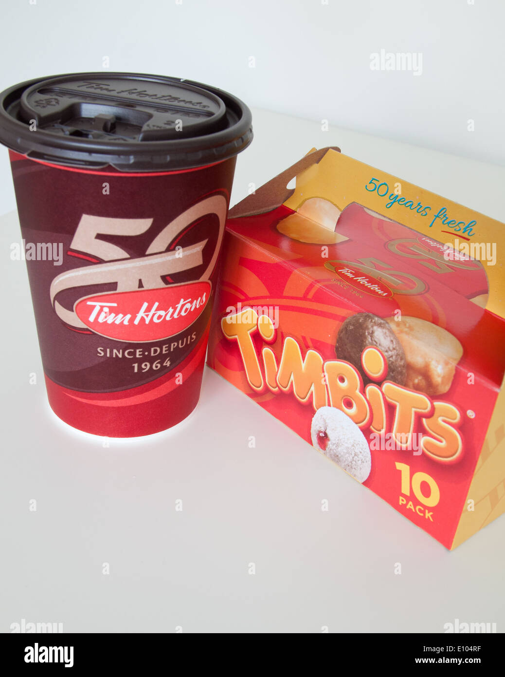 Un Tim Hortons tazza di caffè e Timbits (fori di ciambella, donut fori). In Canada. Foto Stock