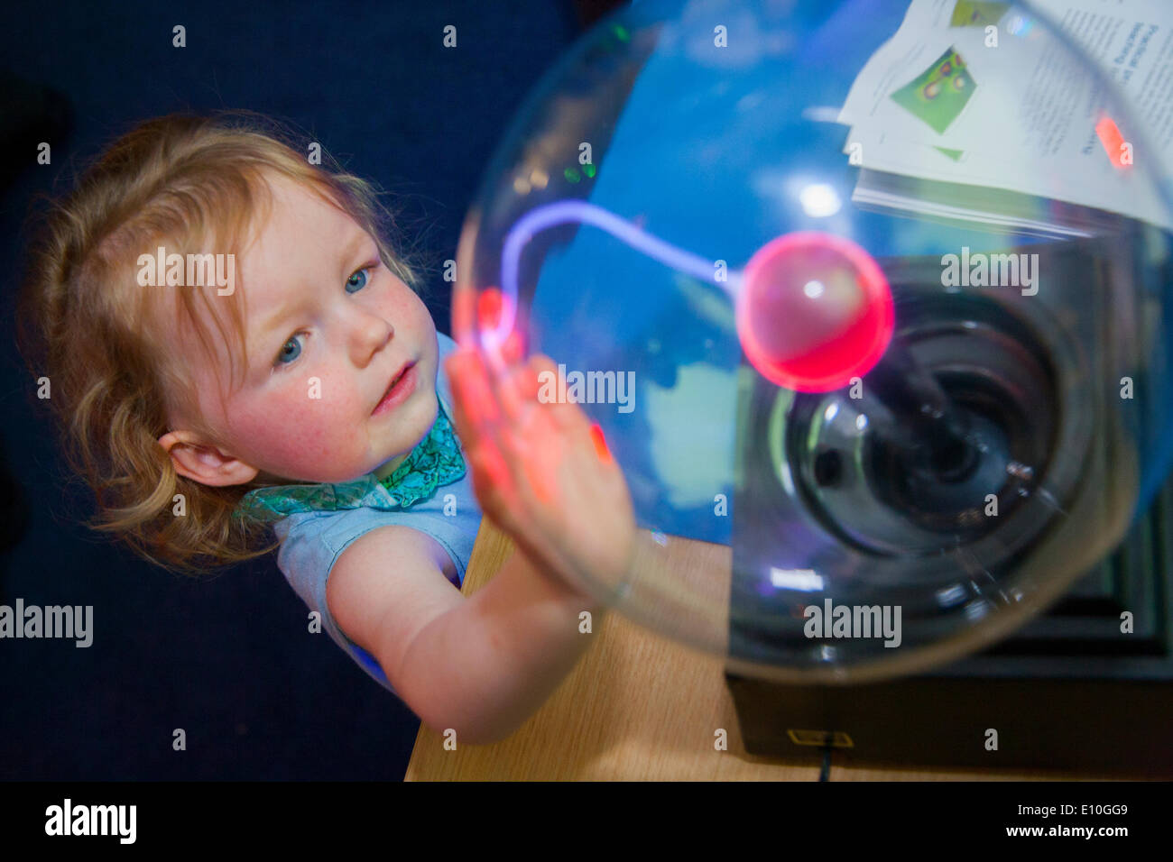 Visitatore - invecchiato 2 anni - gode di giocare con una palla al plasma sul display durante una rara Open Day presso il National Physical Laboratory di Teddington, Londra, Regno Unito. Foto Stock