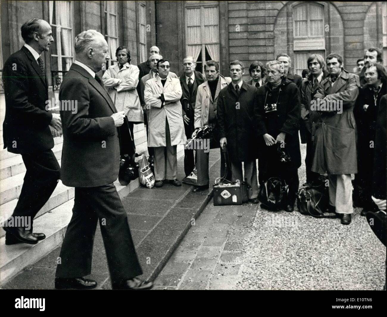 Mar 20, 1974 - In uno sforzo per protestare contro una legge che impedisce loro di avere la sorveglianza permanente presso gli ingressi e le uscite dell'Elysee Palace, premere questi fotografi ha rifiutato di prendere le immagini dei Ministri lasciando la loro riunione del Consiglio di ieri pomeriggio. Con le braccia incrociate e le loro macchine fotografiche sul terreno, premere i fotografi guardare Pierre Messmer e di Giscard d'Estaing uscire dall'Elysee Palace. Foto Stock