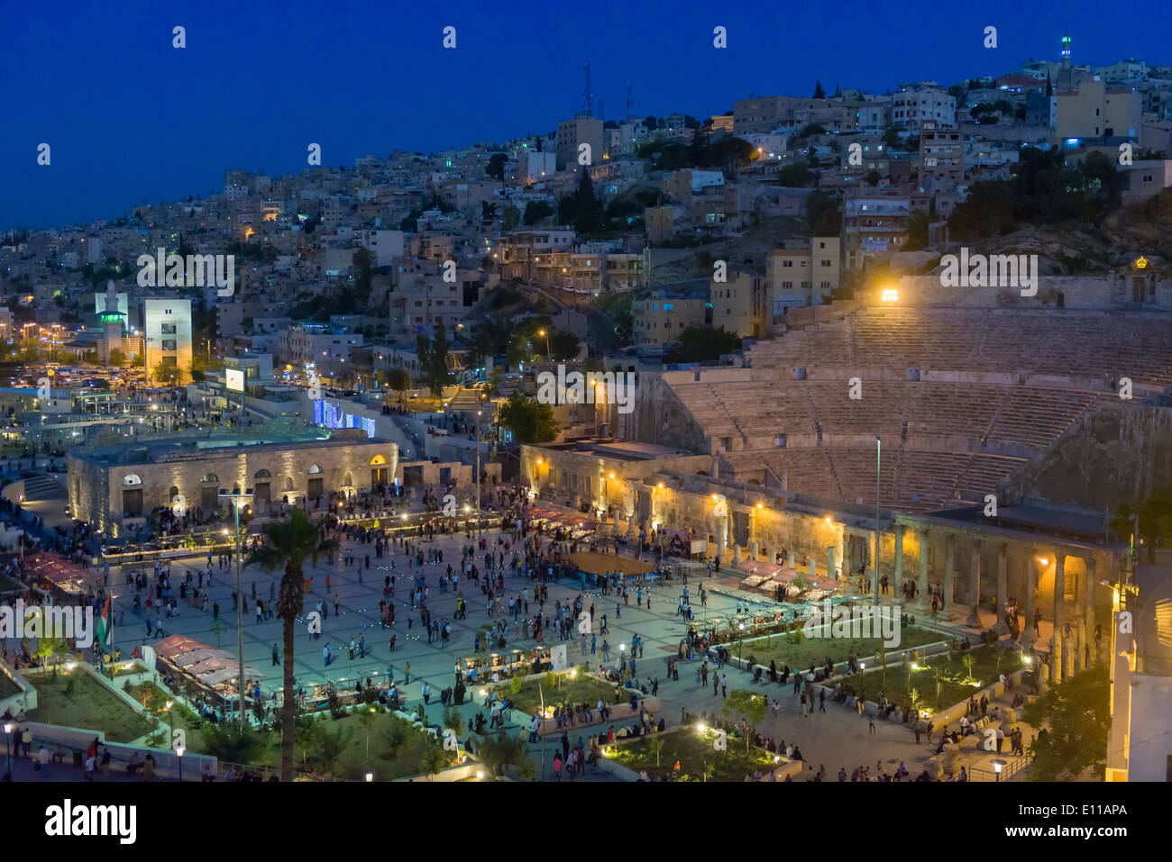 Guardando verso il basso sul Teatro Romano e la vivace piazza di fronte alla notte, Amman, Giordania Foto Stock