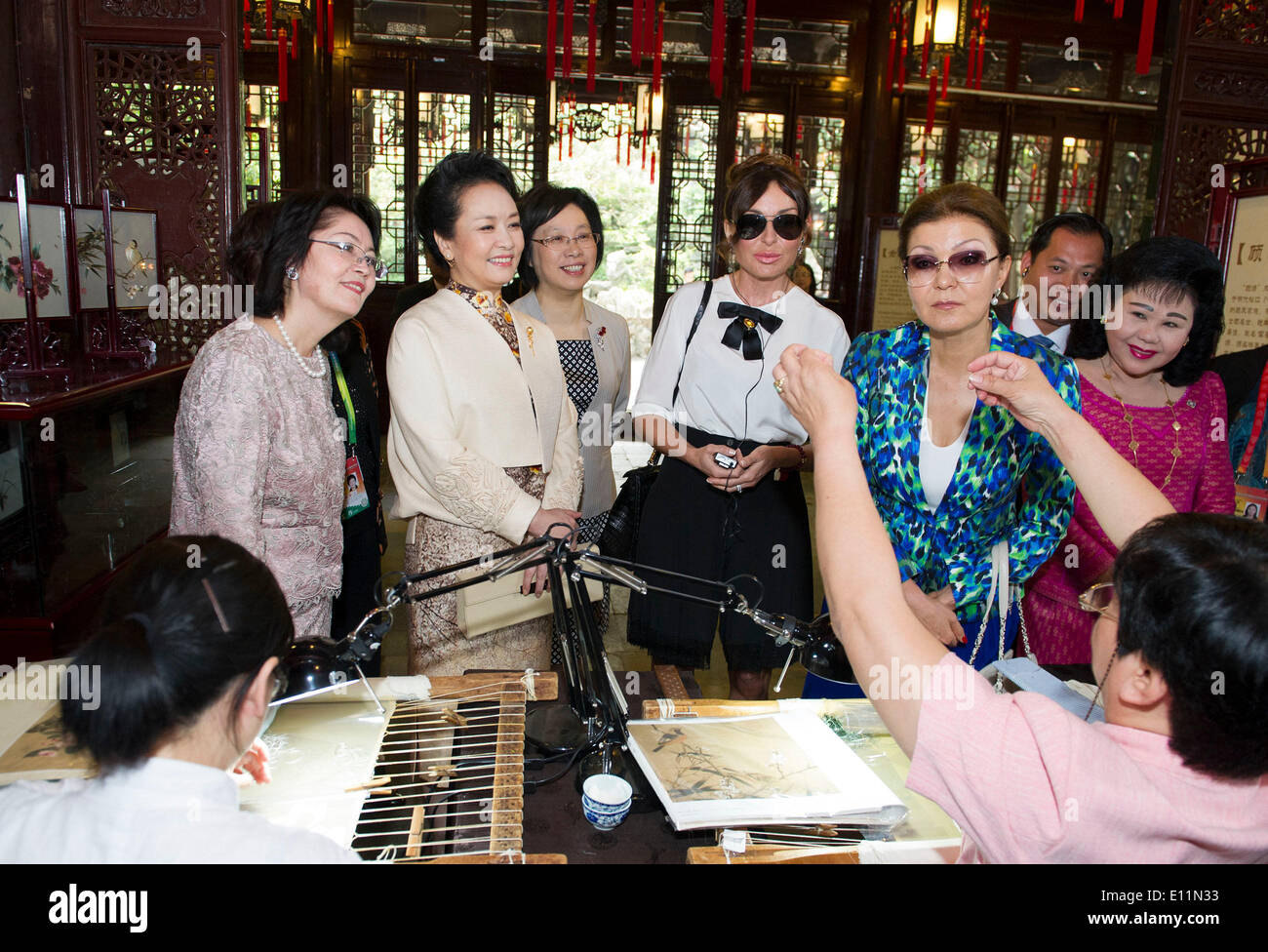 Shanghai Shanghai. 21 Maggio, 2014. Peng Liyuan (2 L), la moglie del Presidente cinese Xi Jinping, insieme con i coniugi di leader politici di tutto il mondo che frequentano il quarto vertice della conferenza sull'interazione e le misure miranti a rafforzare la fiducia in Asia (CICA), orologi Su Huiping, successore di cinesi non materiale patrimonio culturale Gu ricamo, dimostrando il mestiere di Gu Ricami in Shanghai, 21 maggio 2014. © Huang Jingwen/Xinhua/Alamy Live News Foto Stock