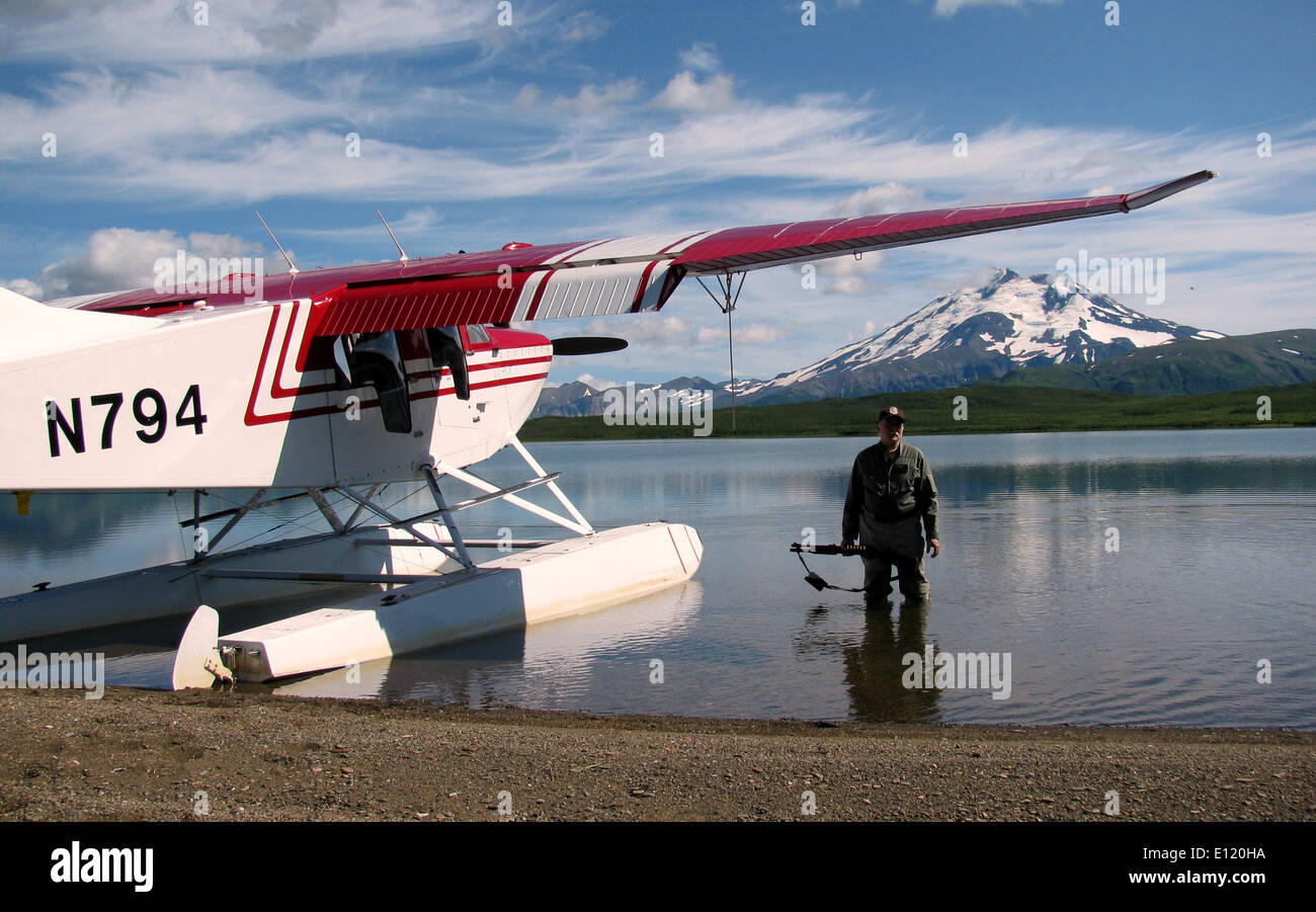 Pete Finley, un pilota dell'Alaska Peninsula National Wildlife Refuge, è visto vicino al suo aereo Bushhawk sul lago Mother Goose. Quest'area è conosciuta per la sua ricca fauna selvatica e gli ambienti incontaminati, che la rendono una posizione privilegiata per la conservazione e il monitoraggio della fauna selvatica. Foto Stock