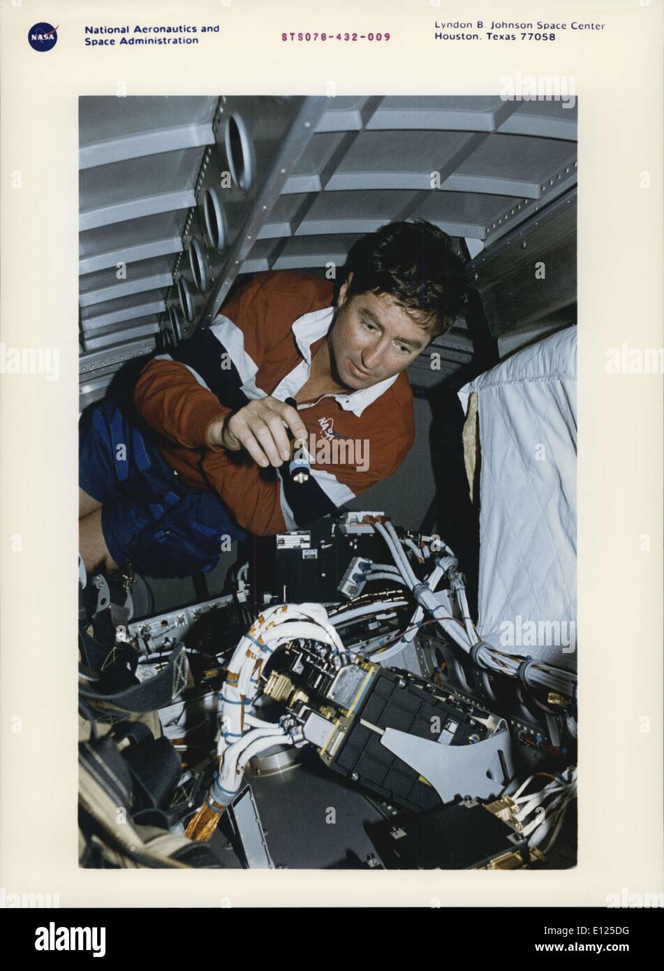 Giugno 20, 1996 - Johnson Space Center Houston, Texas: STS-78 vista di bordo - tra gli interventi di manutenzione a bordo (IFM) mansioni che sono state gestite da membri di equipaggio durante il loro quasi 17 giorni nello spazio a bordo della navetta spaziale Columbia è stato uno che ha coinvolto andando nell'alloggiamento al di sotto del pavimento della vita e la microgravità Spacelab (LMS-1) Scienza modulo. Astronauta Terence T. (Tom) Henricks, comandante della missione, brilla una piccola torcia elettrica su alcuni cavi relativi alla LMS-1 supportati sistemi di computer. Come nel caso delle altre IFM faccende, Henricks' sforzi sono stati coronati da successo Foto Stock