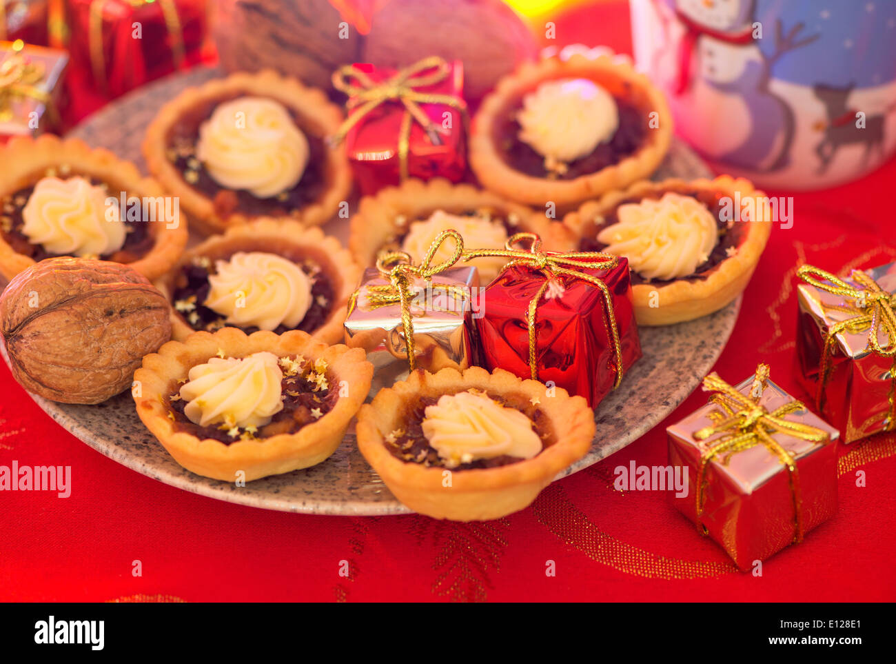 mince torte sul piatto su tovaglia rossa festiva Foto Stock