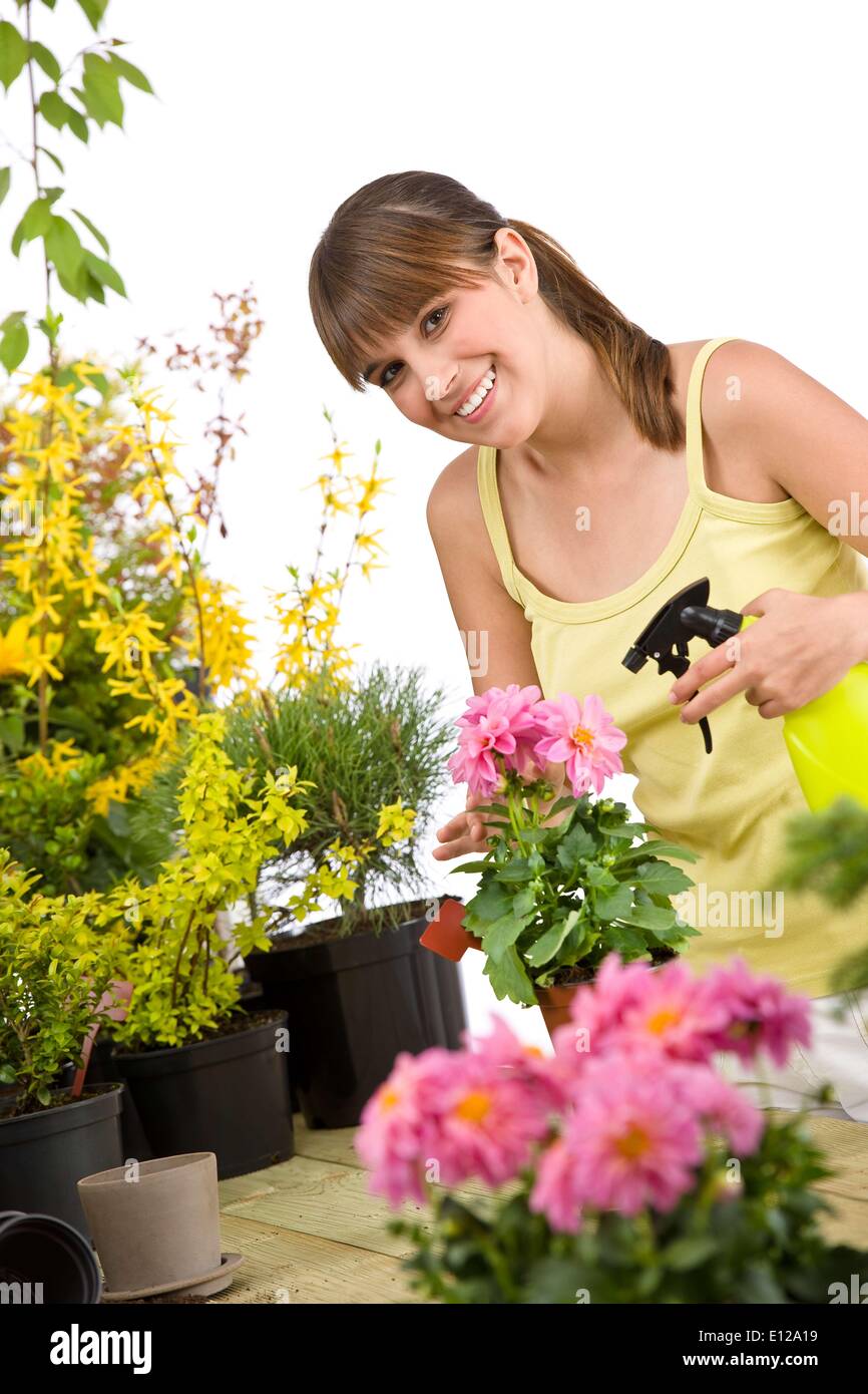 01 maggio 2010 - 1 Maggio 2010 - giardinaggio - Donna sorridente con fiore e impianti sprinkler su sfondo bianco Foto Stock