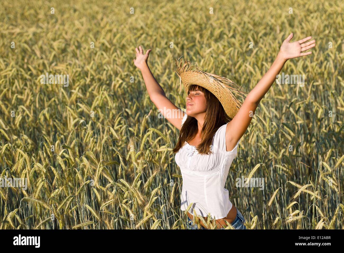 Lug. 12, 2010 - Luglio 12, 2010 - Happy donna con cappello di paglia godersi il sole nel campo di mais Ã Â© CTK/ZUMAPR) Foto Stock
