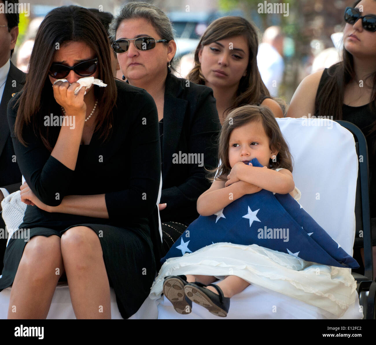 Vicki Baker, sinistra, vedova di U.S. Army Sgt. 1. Classe Jeffrey Baker, piange mentre la loro figlia detiene una bandiera statunitense durante il quarantacinquesimo annuale di l'eliminazione degli ordigni esplosivi Memorial Wall cerimonia Maggio 3, 2014 a Eglin Air Force Base in Florida. Otto nomi di Marines e soldati sono stati aggiunti, portando il totale a 306. Foto Stock